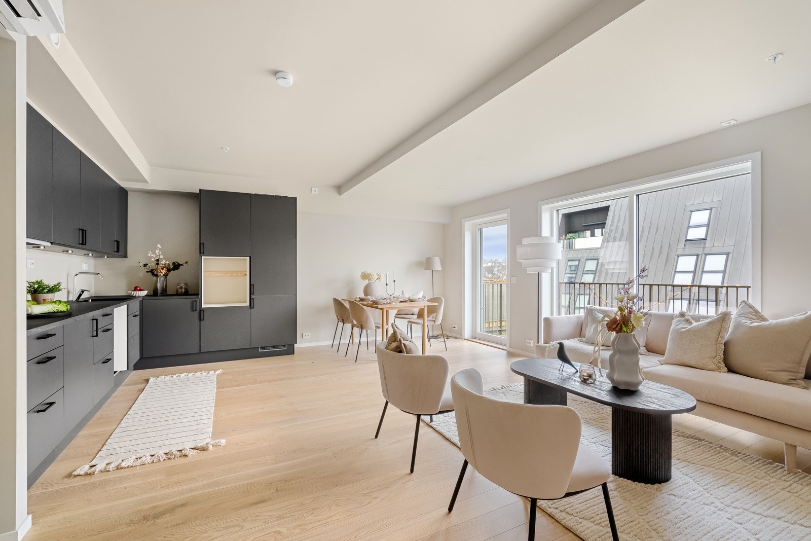 Lys innbydende stue med store vindusflater og utgang til balkong hvor man kan nye ettermiddag- og kveldssol Galleribilde