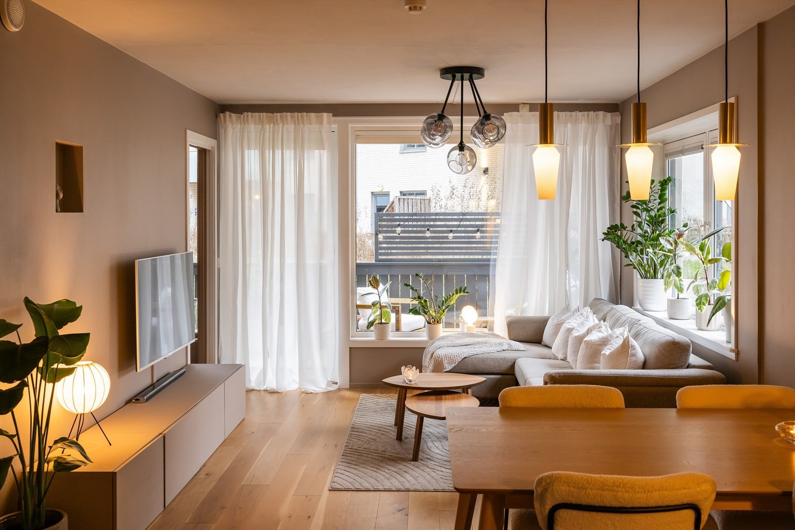 Kveldsstemning i stuen. I 2019 ble det montert elegante plissegardiner på alle vinduene i stuen fra Markisemannen, som gir både en moderne og tidløs atmosfære. Galleribilde