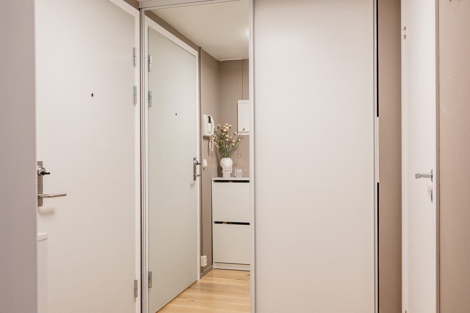 Entréen er både praktisk og stilfull, med en romslig skyvedørsgarderobe som gir god plass til oppbevaring av yttertøy, sko og tilbehør. Galleribilde