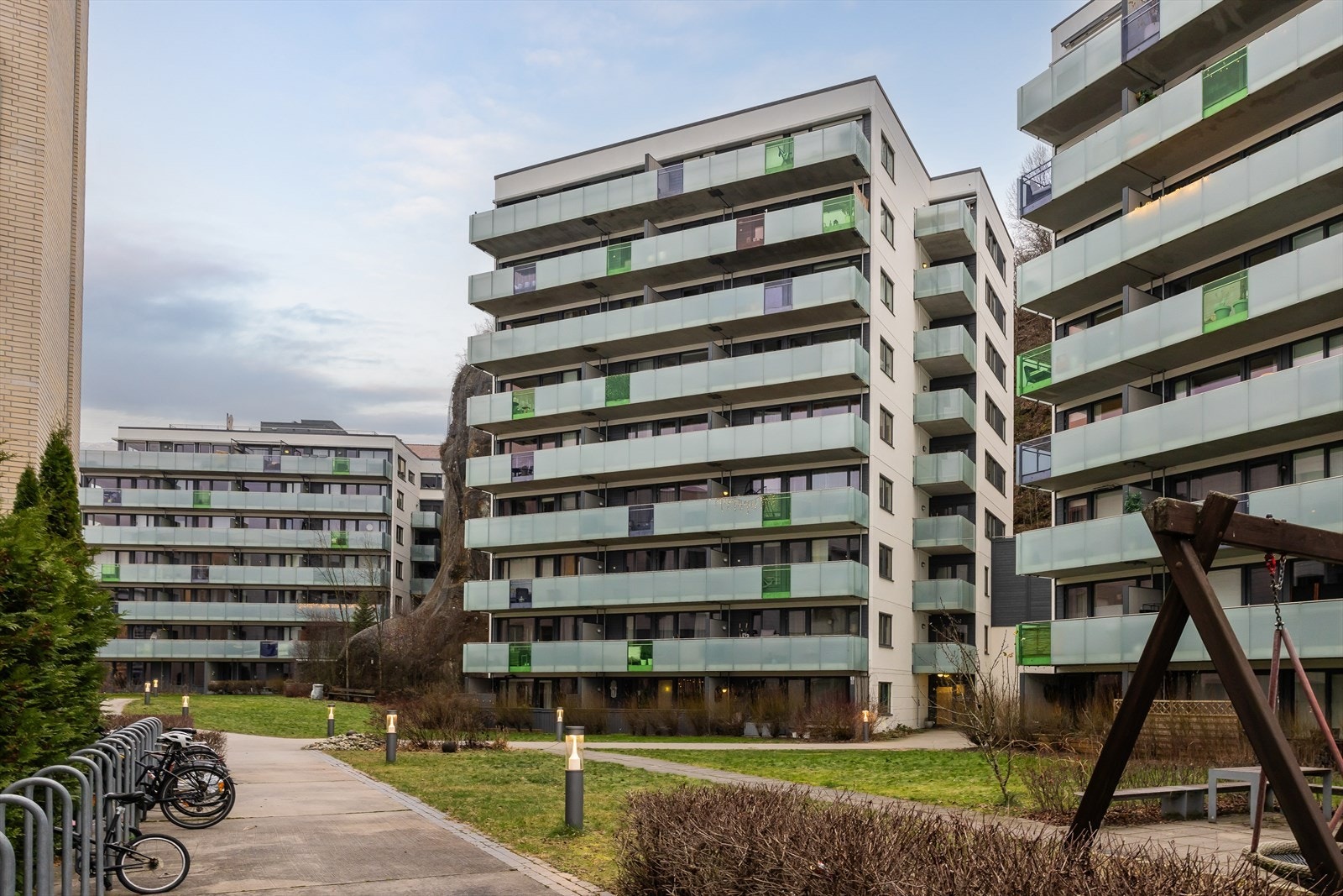 Felles tomten er pent opparbeidet med sitteplasser, velpleide plener og vakre beplantninger som skaper en trivelig og rolig atmosfære. Galleribilde