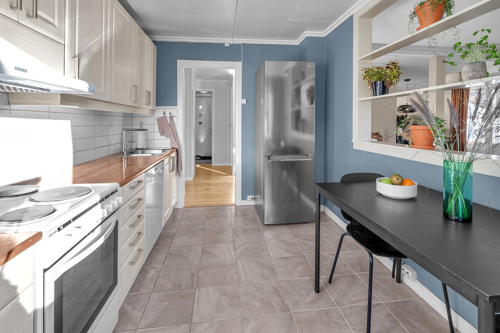 Åpning i vegg mellom kjøkken og stue som skaper en sosial sone Galleribilde