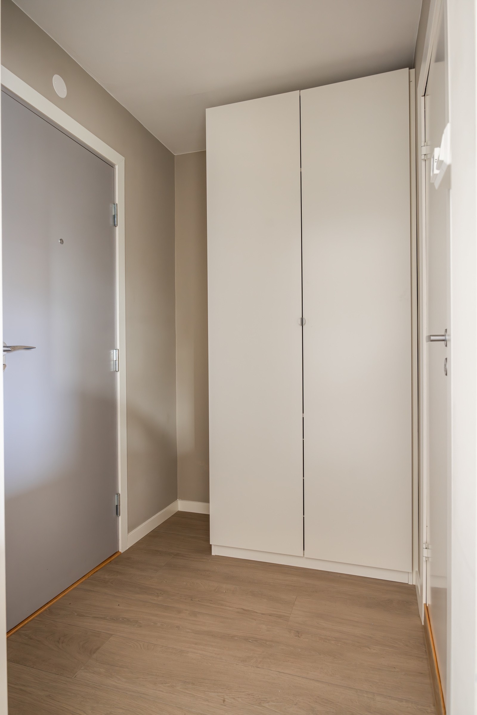 Entréen har moderne standard fra 2024 med pent enstavsgulv, glatte overflater malt i en fin varm farge og skjult elektrisk anlegg. God plass til sko og yttertøy i medfølgende garderobeskap. Galleribilde