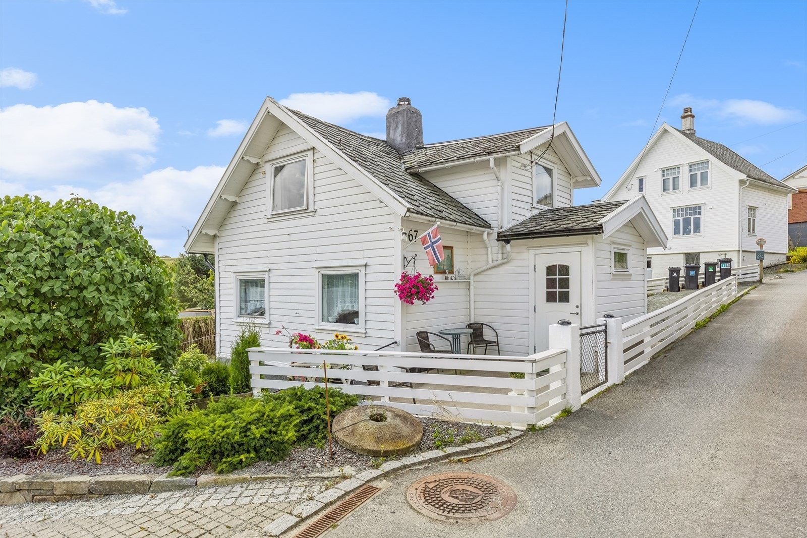 Huset har en svært sjarmerende karakter, omringet av gjerde og fin beplantning. Galleribilde