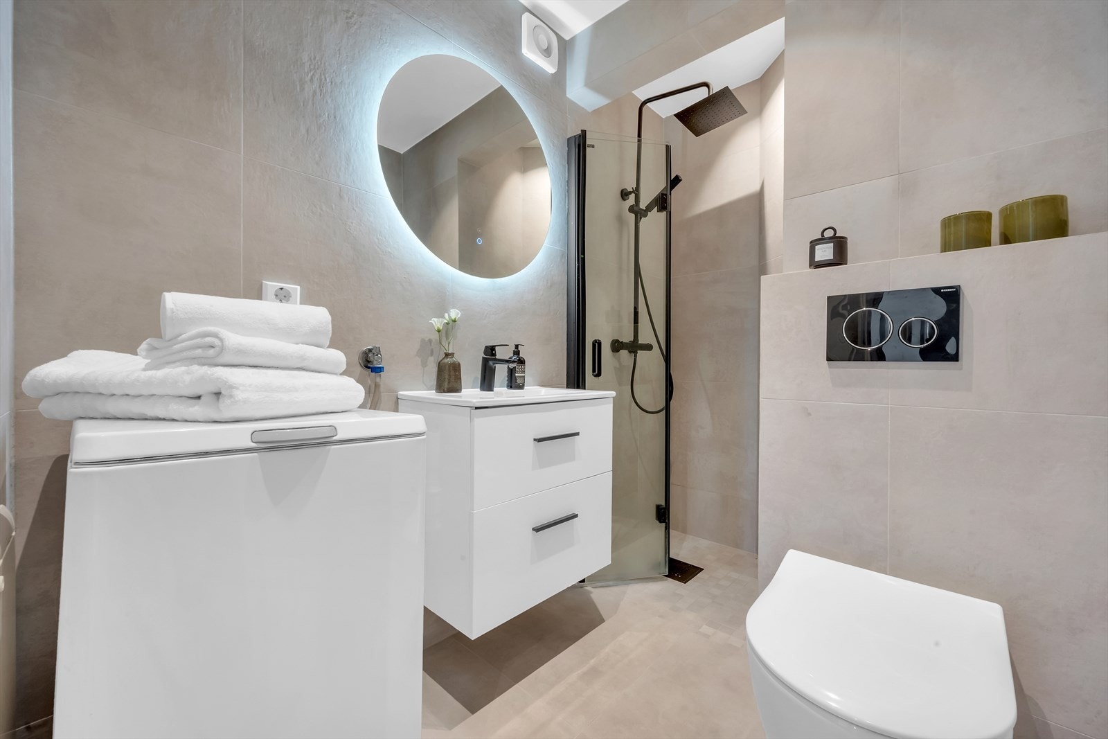 Stilrent flislagt baderom med innfelte downlights og elektrisk gulvvarme, oppusset i 2020. Galleribilde