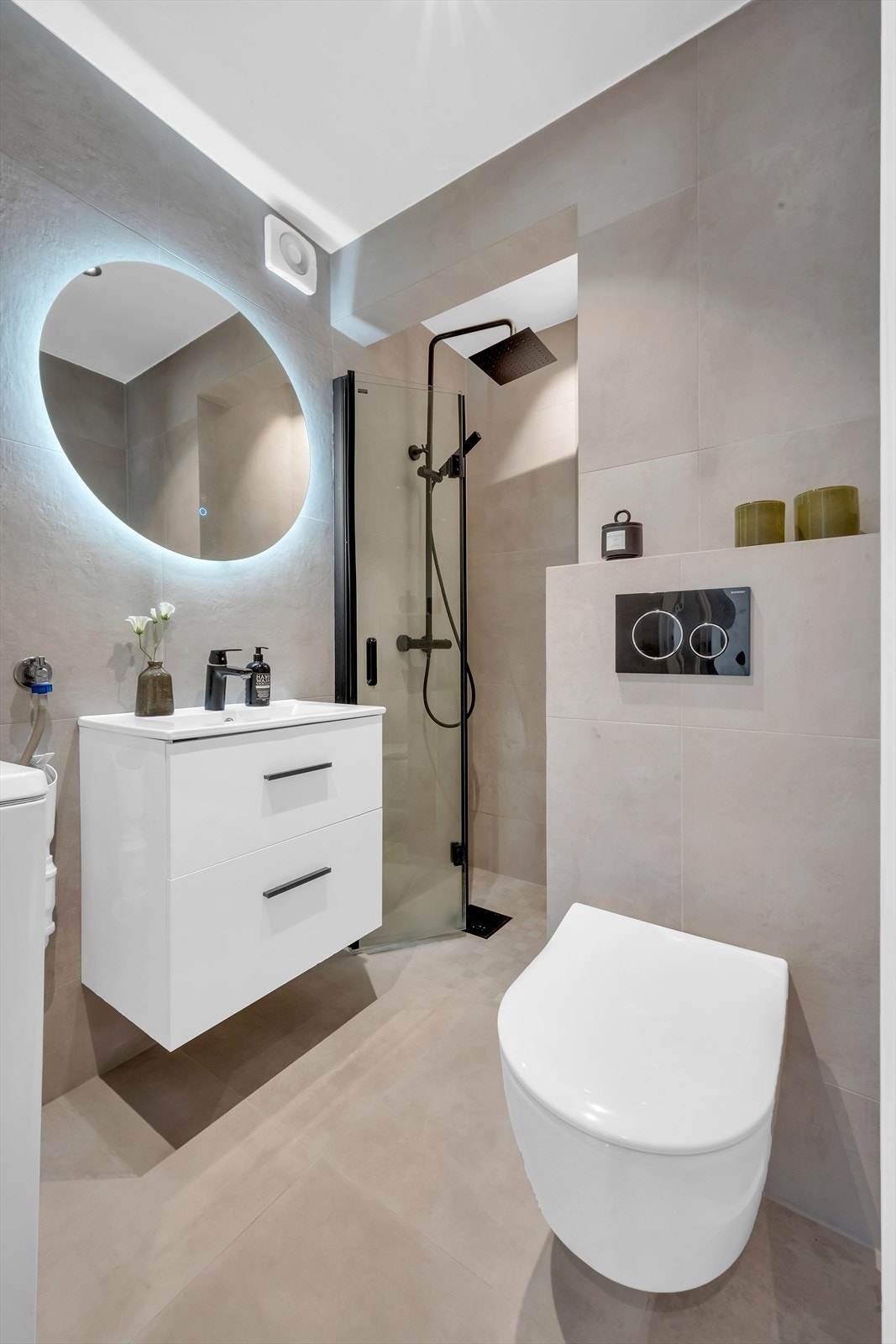 Badet er utstyrt med vegghengt klosett, servant nedfelt i innredning, og et dusjhjørne med svingbare glassdører. Det er tilrettelagt for vaskemaskin, og baderommet har en elektrisk styrt ventilasjonsvifte for god luftkvalitet. Galleribilde