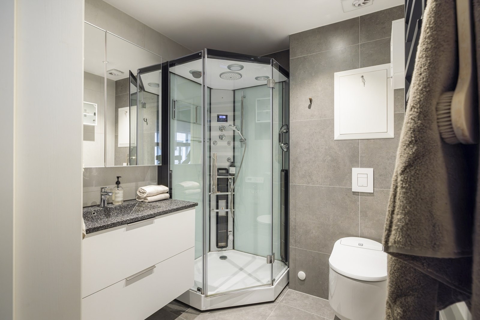 Badet har store fliser i moderne farger. Galleribilde