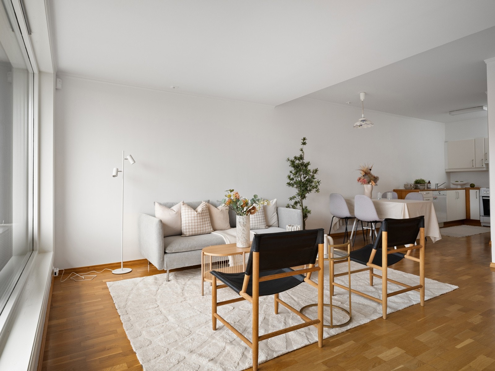 Stue og kjøkken i en fin åpen løsning med plass til både sittegruppe og spisebord Galleribilde