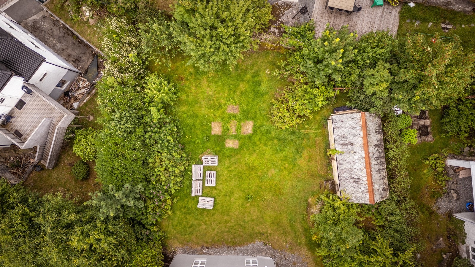 Tomtegrensen går like bak skuret i bakkant og følger hekken i front Galleribilde