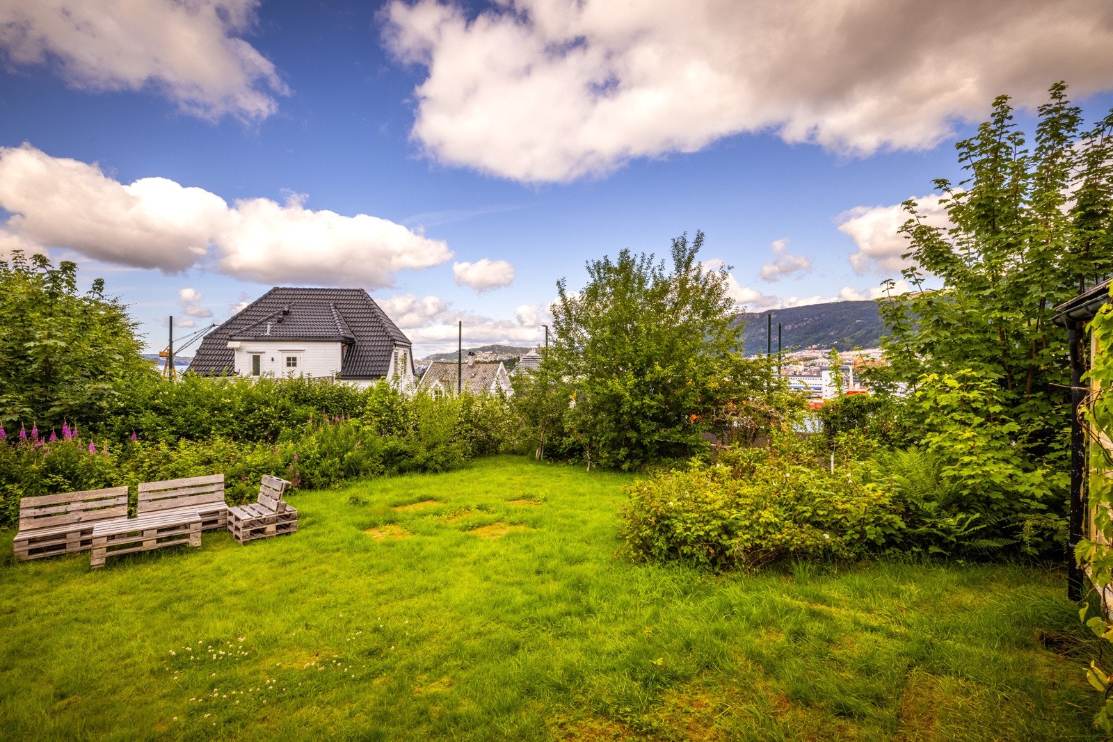 På bakkeplan oppleves eiendommen som en skjult oase takket være vegetasjon og nivåforskjeller Galleribilde