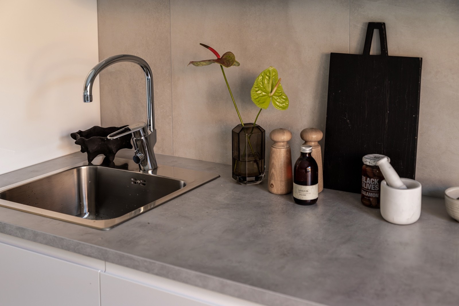 Innredningen har hvite glatte fronter med soft-close og laminert benkeplate med nedfelt oppvaskkum. Praktisk med fliser i benkeryggen og belysning under overskap. Galleribilde