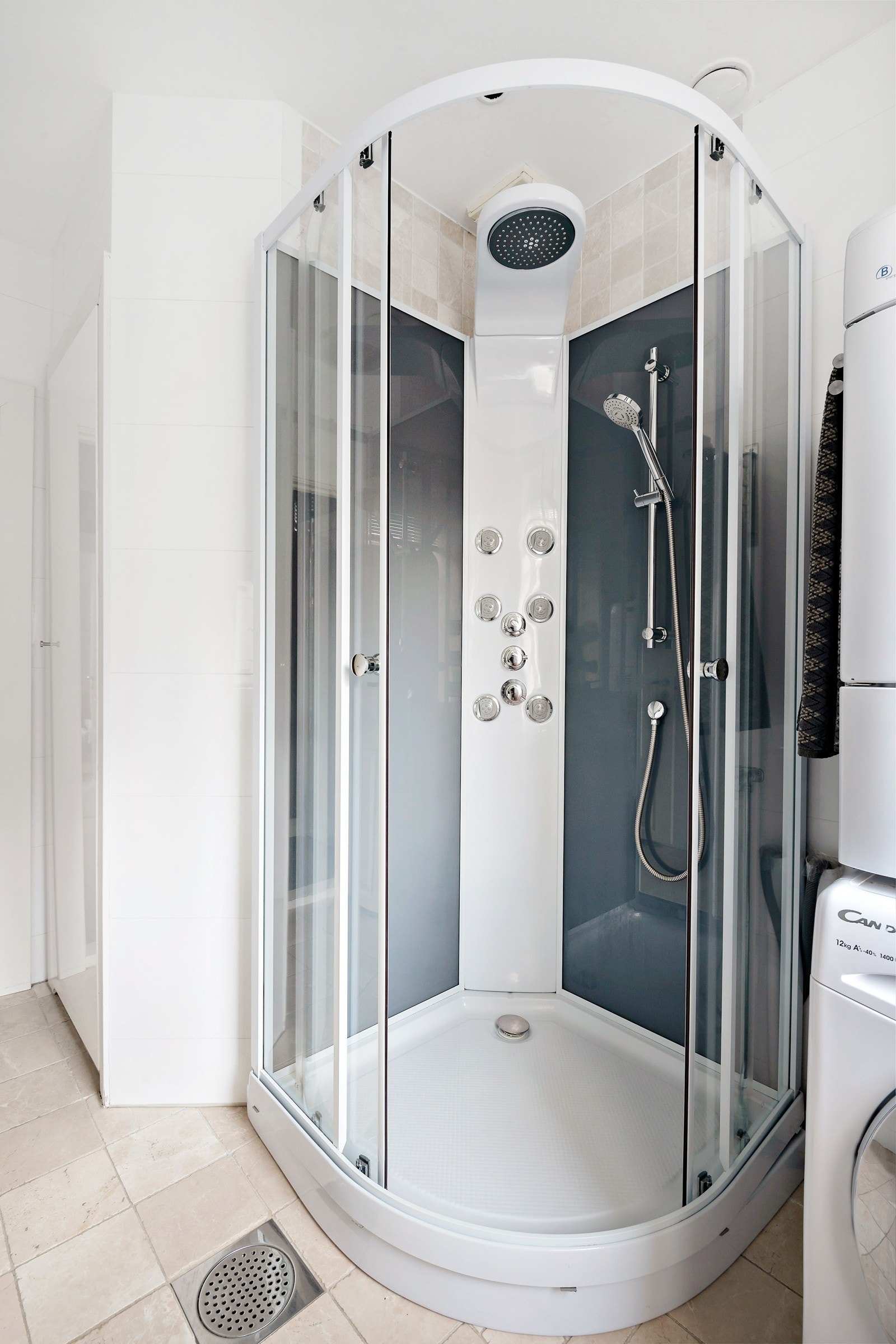 Rommet et innredet med servantinnredning og ovenpåliggende servant, vegghengt speil og dusjkabinett Galleribilde