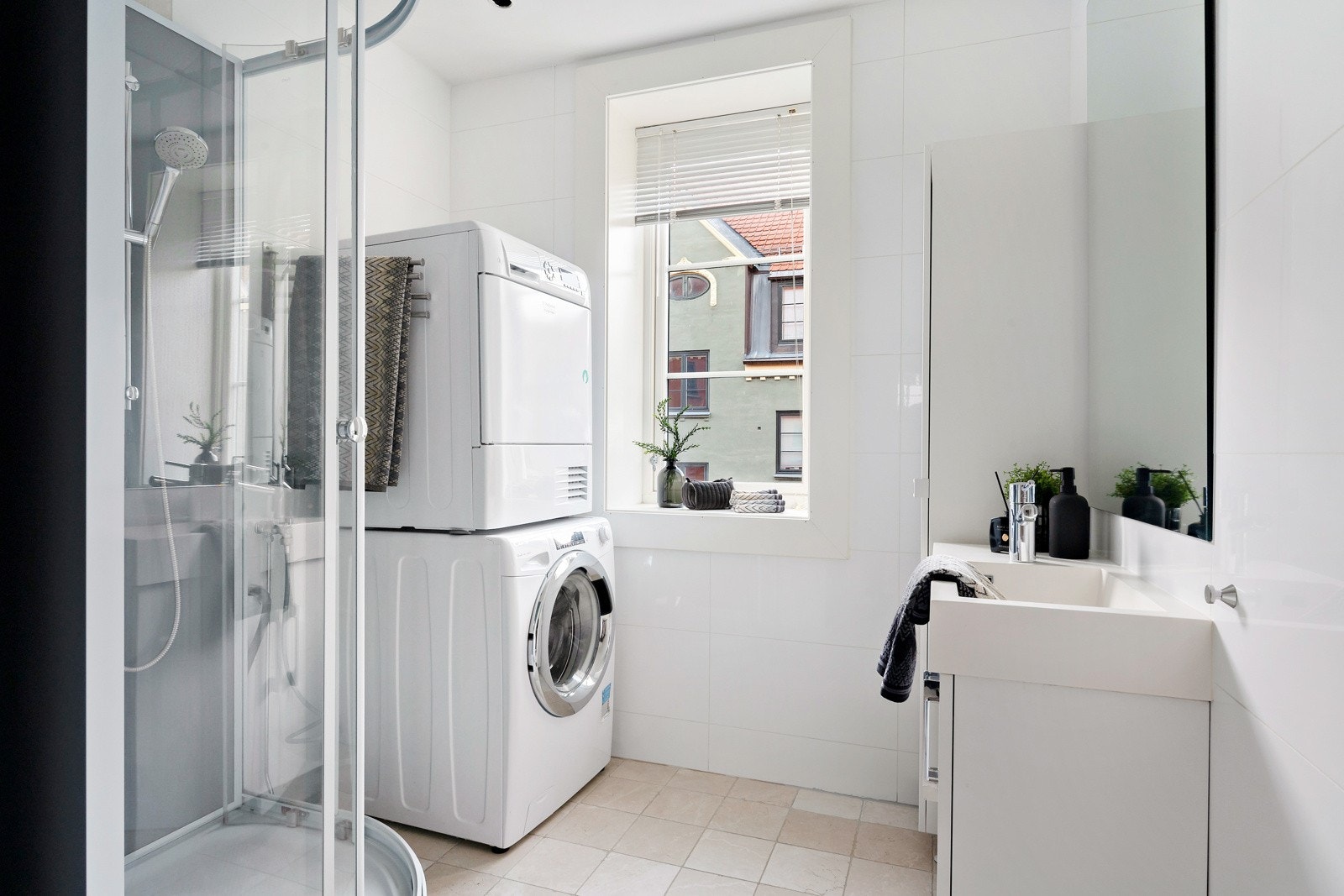 Lyst og helfliset baderom med varme i gulv og downlights i himling. Her er både opplegg og plass for vaskemaskin Galleribilde