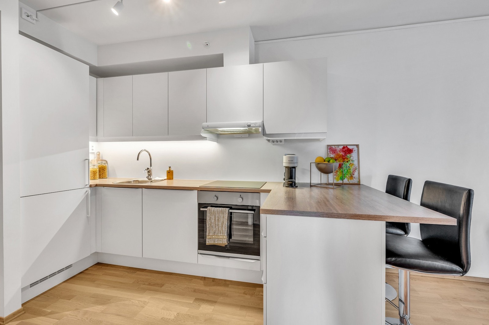 Lyst og stilrent kjøkken med god lagringsplass i skap. Integrerte hvitevarer følger handelen. Galleribilde