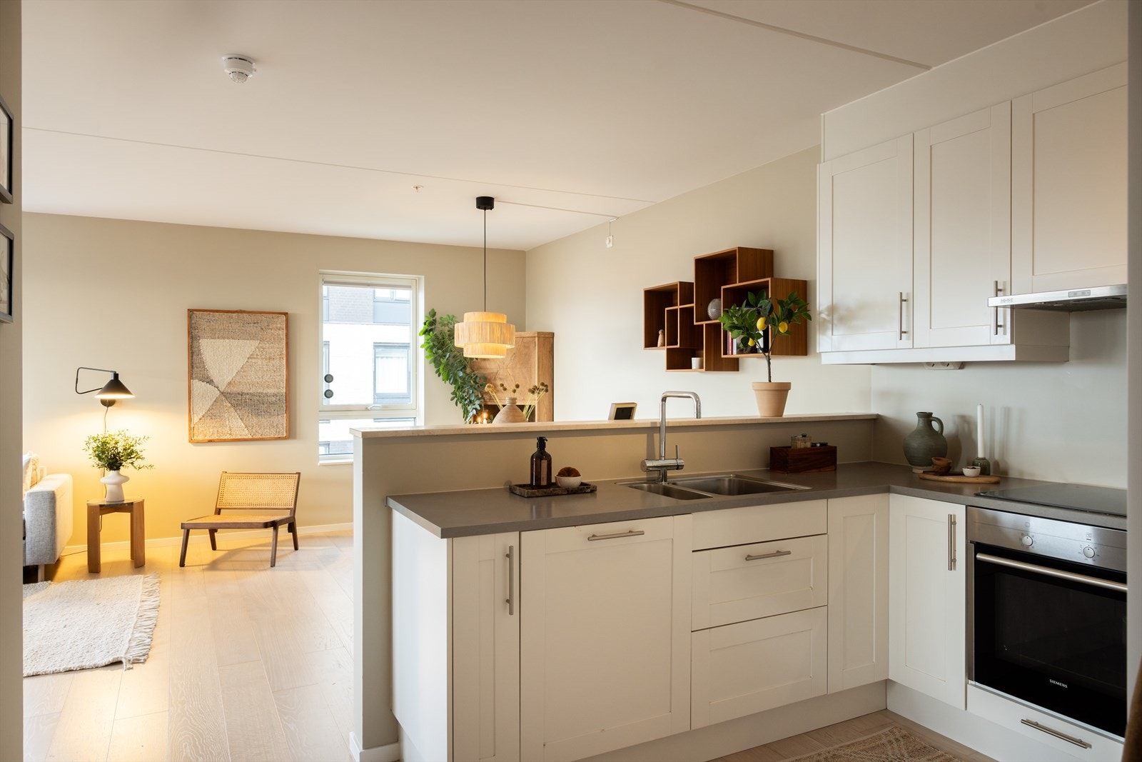 Stilrent kjøkken i åpen løsning mot stue - noe som skaper en sosial atmosfære. Galleribilde