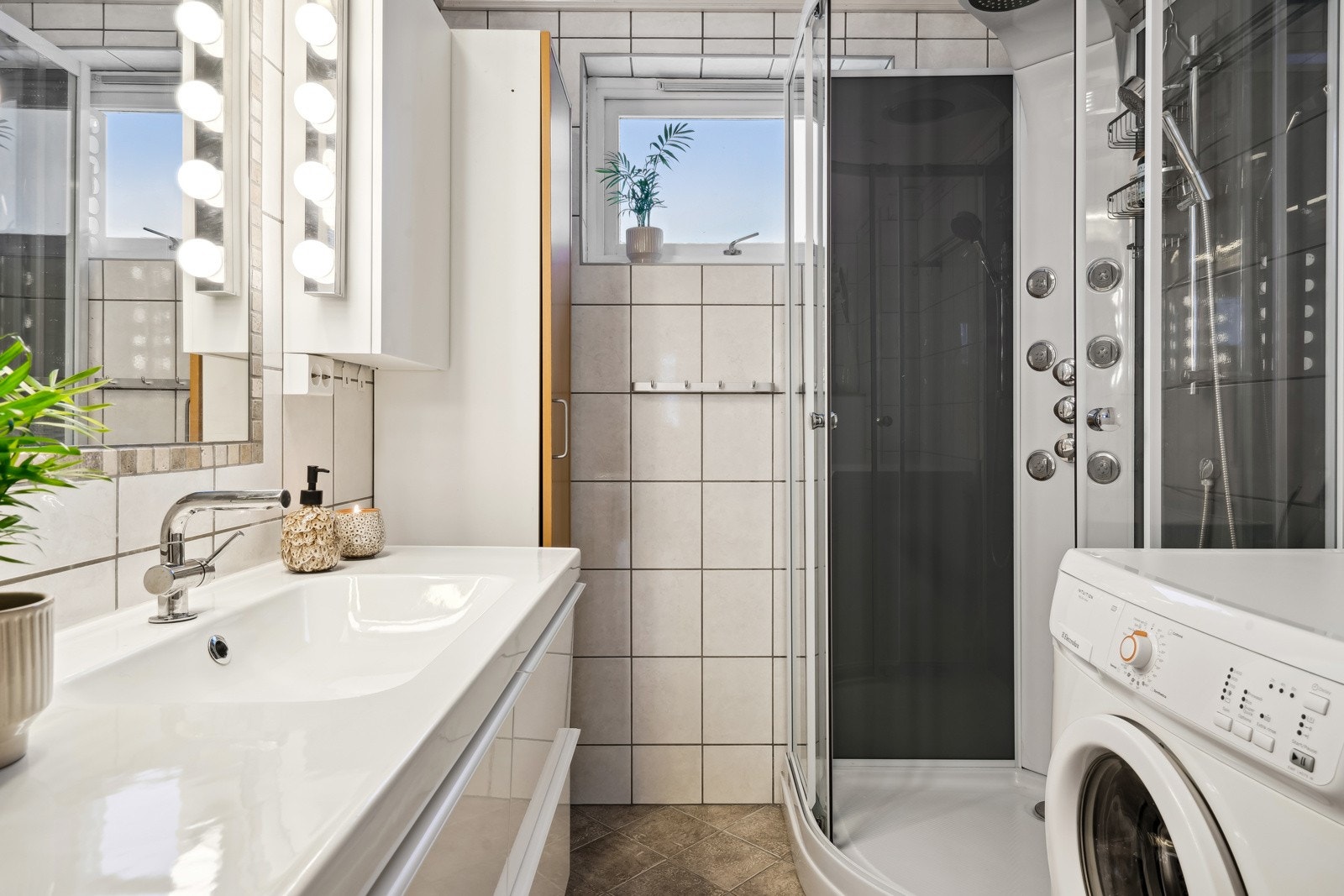 Gulvflate belagt med gulvbelegg, tapeserte veggflater, veggehnegt servant, dusjkabinett, gulvstående toalett og varmtvannsbereder. Galleribilde