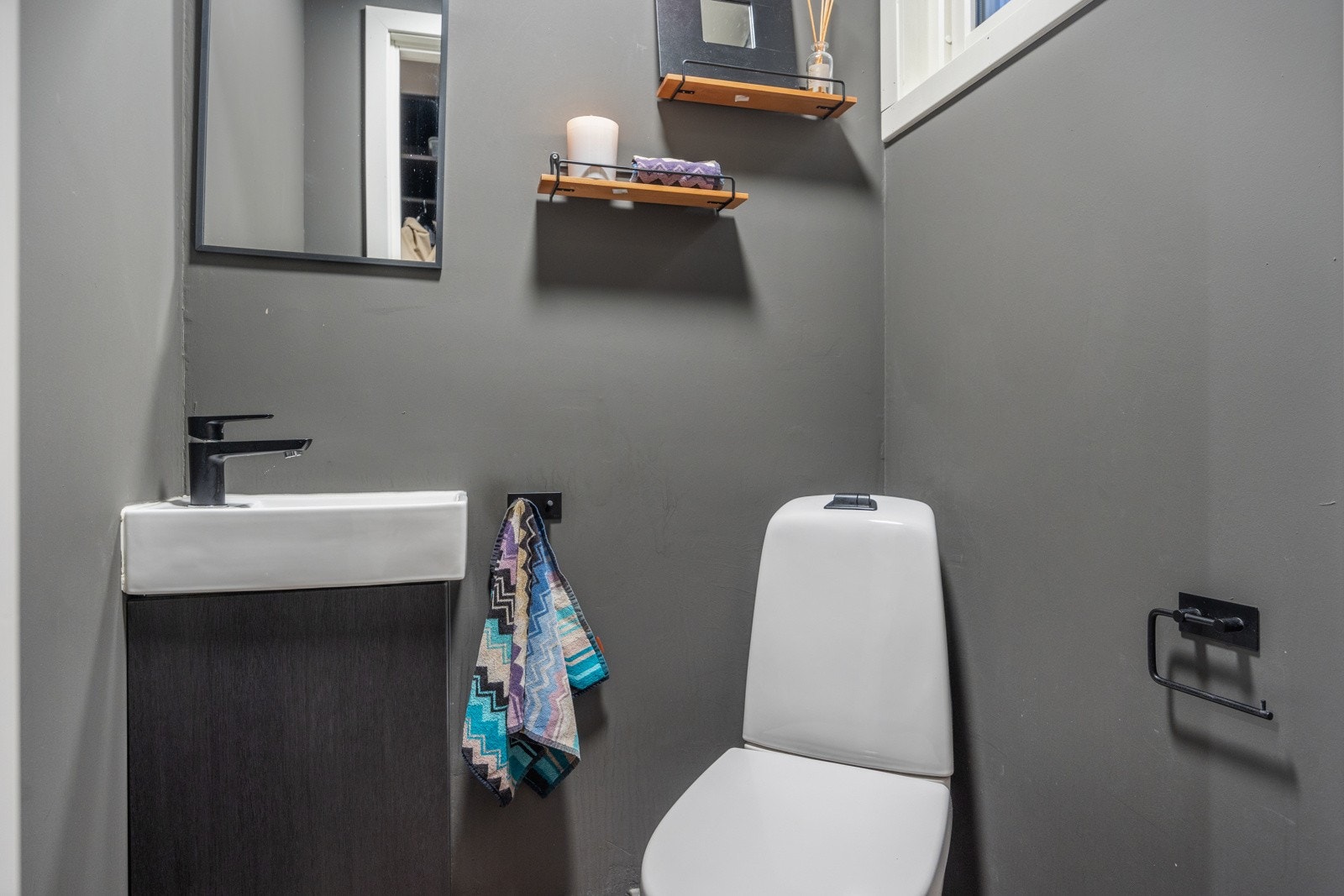 Toalettrommet ved entréen er både funksjonelt og stilfullt, med en moderne vask. Galleribilde