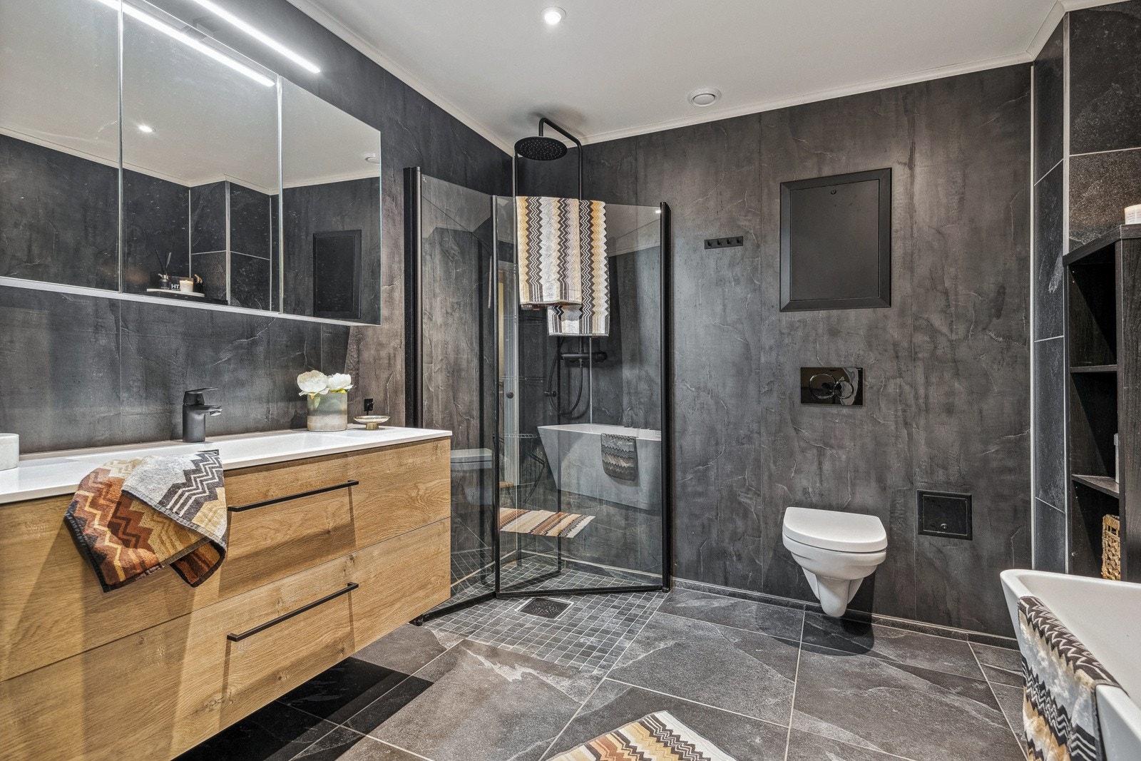 Med fliser i moderne design og gulvvarme, fremstår badet som både delikat og innbydende. Galleribilde