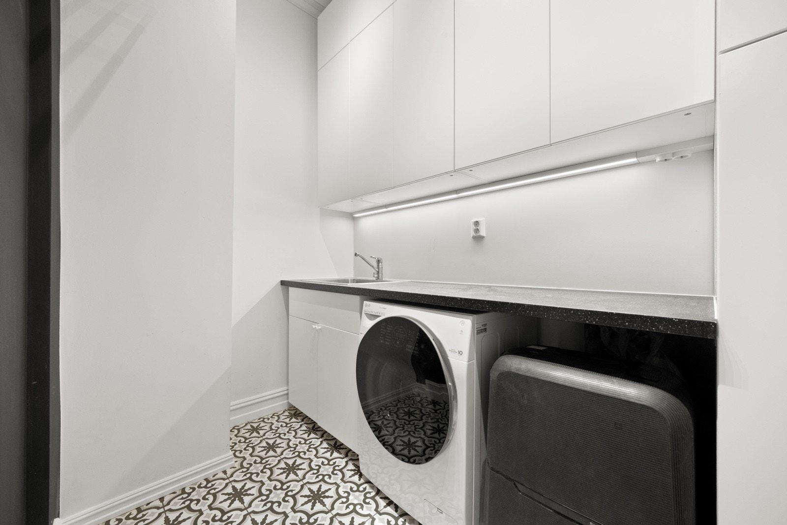 Praktisk separat vaskerom med opplegg for vaskemaskin og kondenstørketrommel. Galleribilde