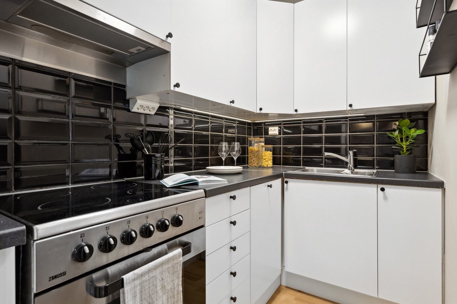 Folierte skrog med slette fronter og laminert benkeplate. Flis på vegg over benkeplate. Galleribilde