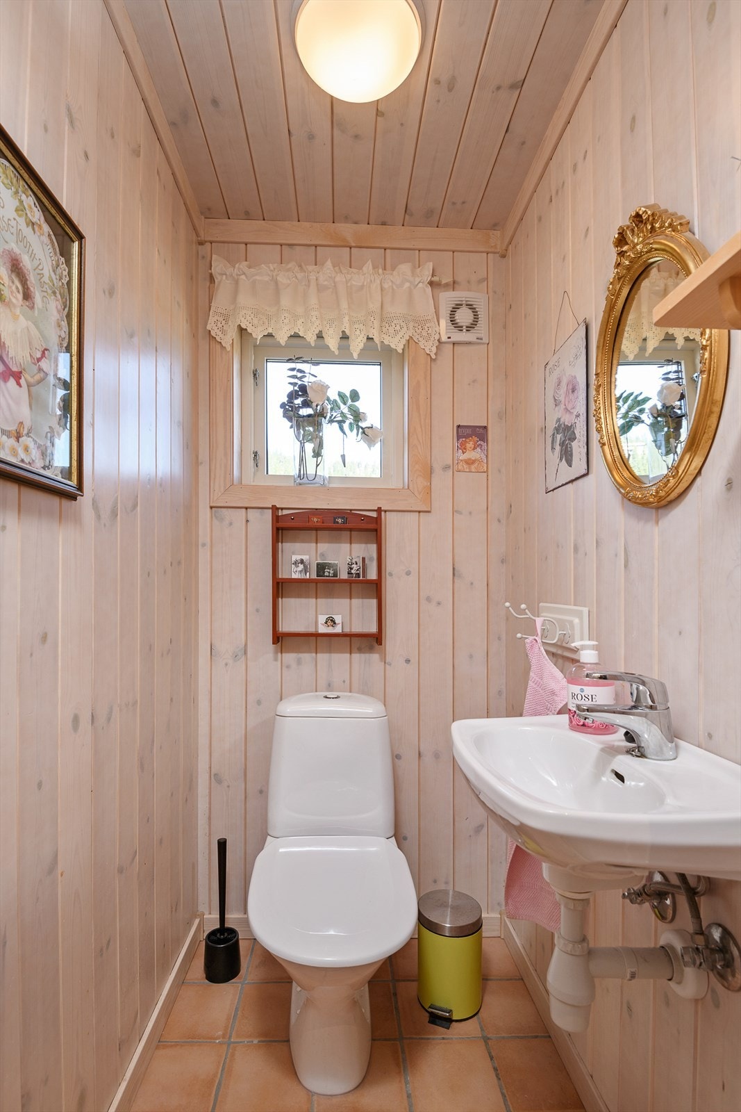 Hytta har et praktisk separat toalett rom med fliser på gulv, panel på vegger, gulvmontert toalett og en vegghengt servant. Galleribilde