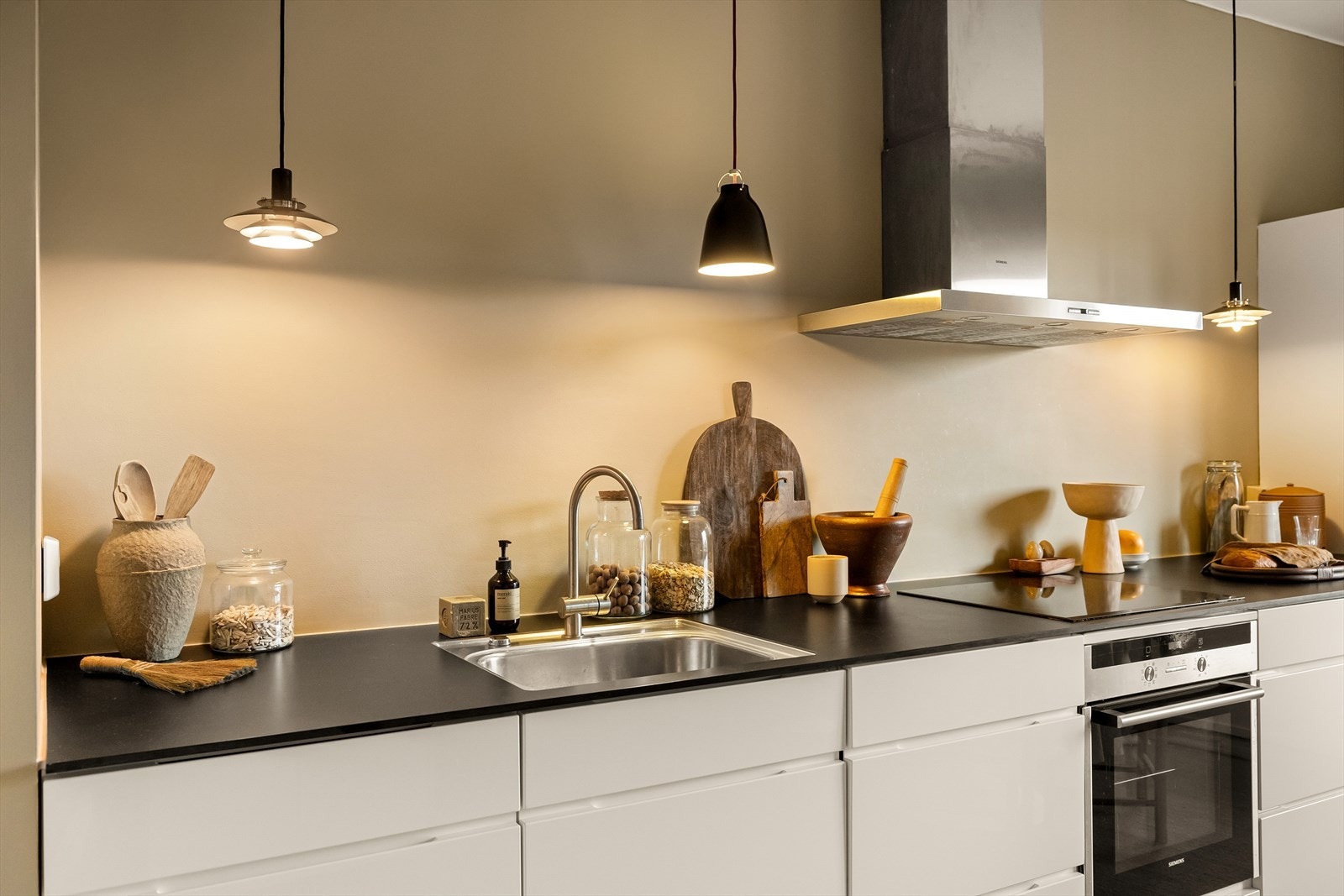 Kjøkkenet har høyglansfronter og en benkeplate med nedfelt kum i rustfritt stål. Det er fullt utstyrt med integrert induksjonstopp, stekeovn, oppvaskmaskin og kjøle-/fryseskap. Galleribilde