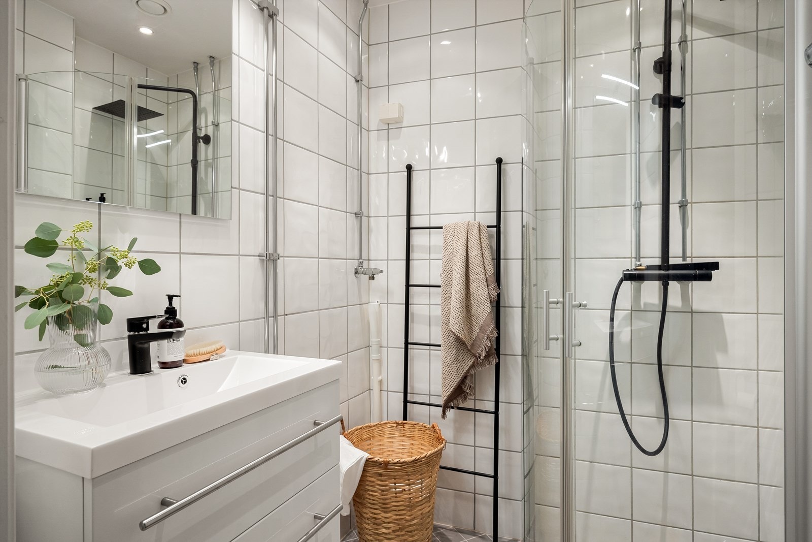 Badet har et servantskap med høyglansfronter, heldekkende servant, samt speil og lysarmatur på veggen over servanten. Det er utstyrt med veggmontert klosett og opplegg for vaskemaskin. Galleribilde