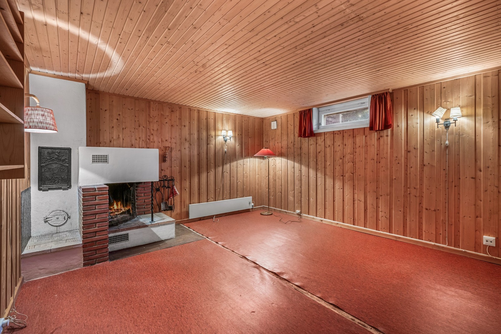 I kjelleren finnes et større rom som er innredet som en kjellerstue. Peisen skal ha blitt satt inn 1977 samtidig som boligen ble påbygd. Galleribilde