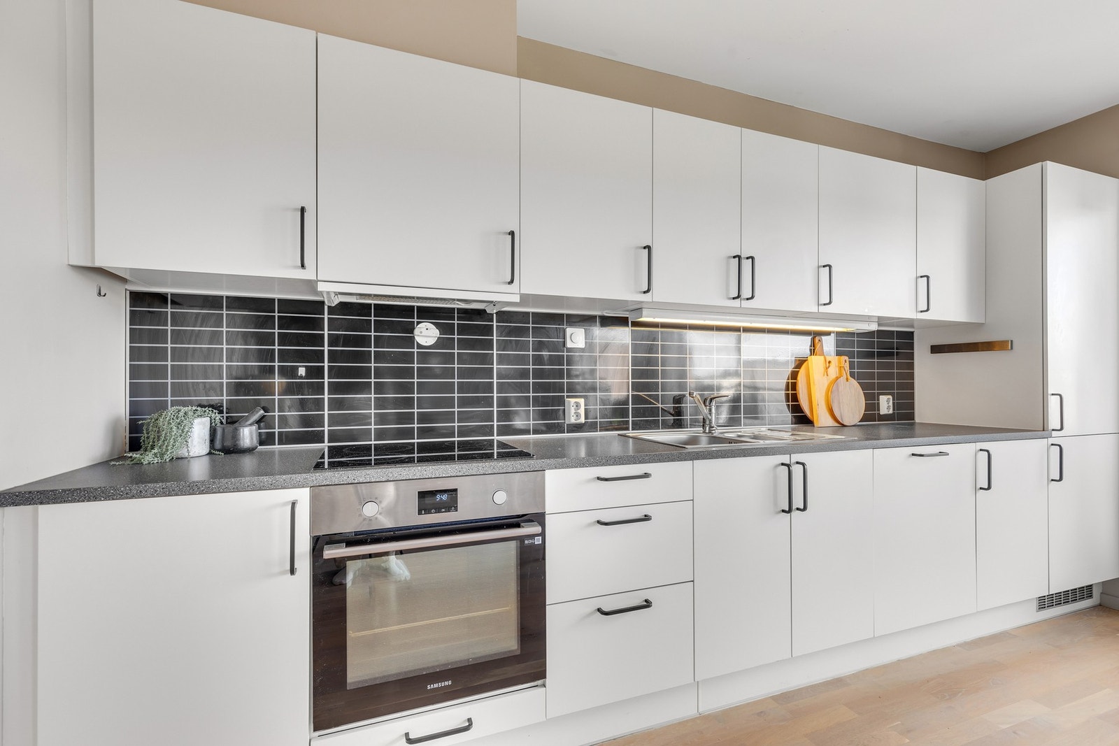 Lyst og tidsriktig kjøkken med integrerte hvitevarer. Galleribilde