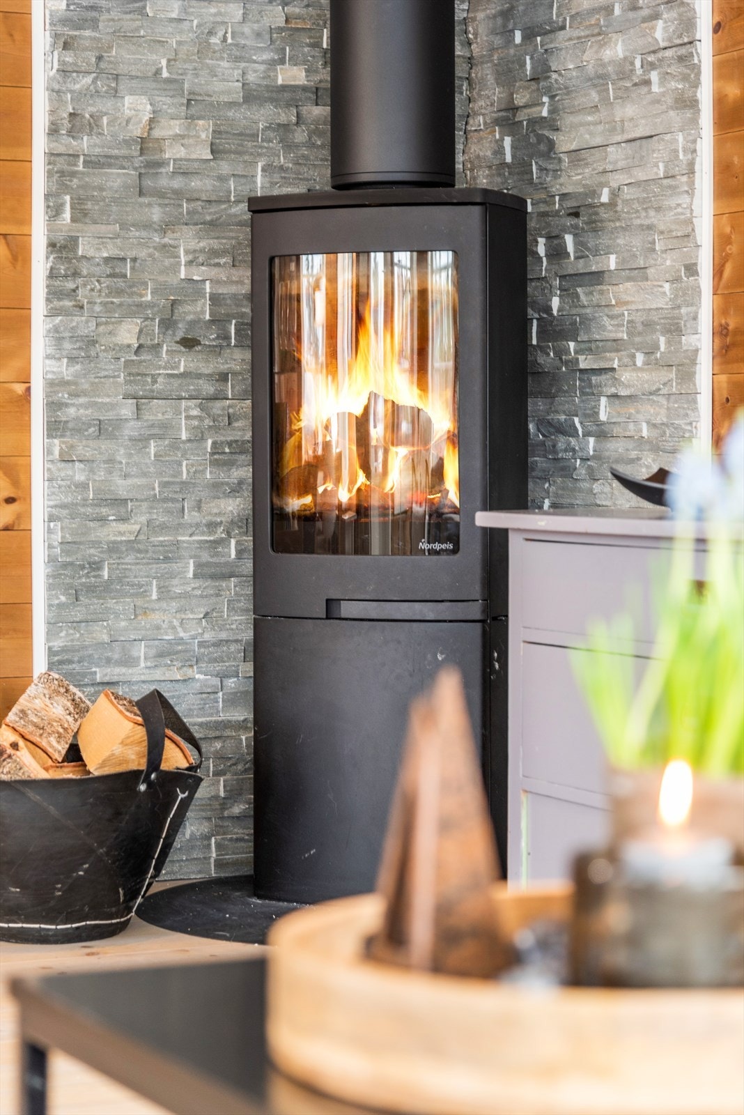 Peisen er rentbrennende og varmer godt på kalde dager. Skiferbelagt vegg ved peisen gir et rustikk og røft preg. Galleribilde
