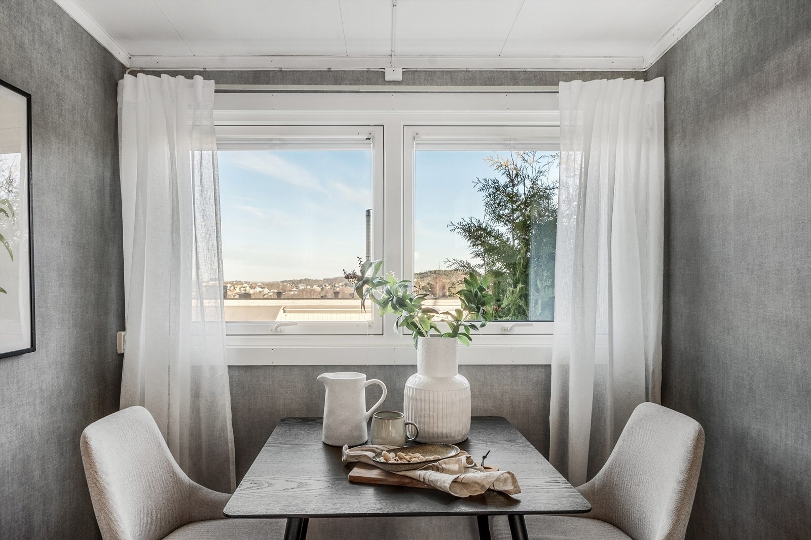 Innerst i rommet er det en hyggelig plass for frokostbord under vindu med utsyn mot nabolaget. Galleribilde