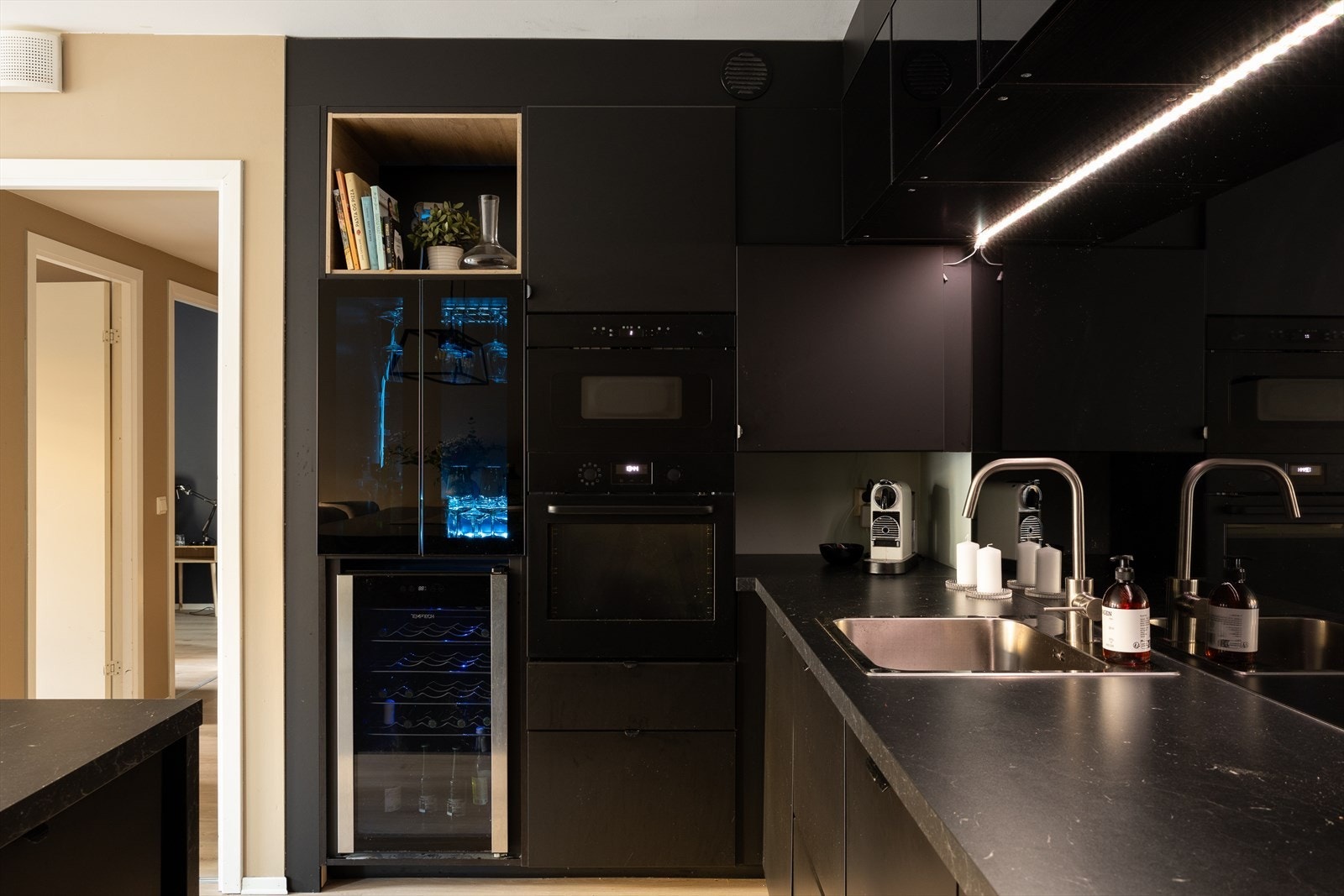 Kjøkkenet har praktisk utforming og kjøkkenøy, samt en smart nisje for de mindre kjøkkenapparatene Galleribilde