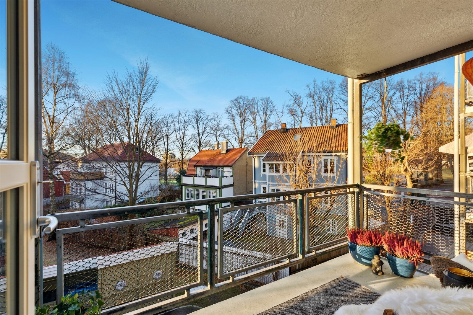 Stor solrik balkong med flott utsikt over nabolagets trehusbebyggelse. Galleribilde
