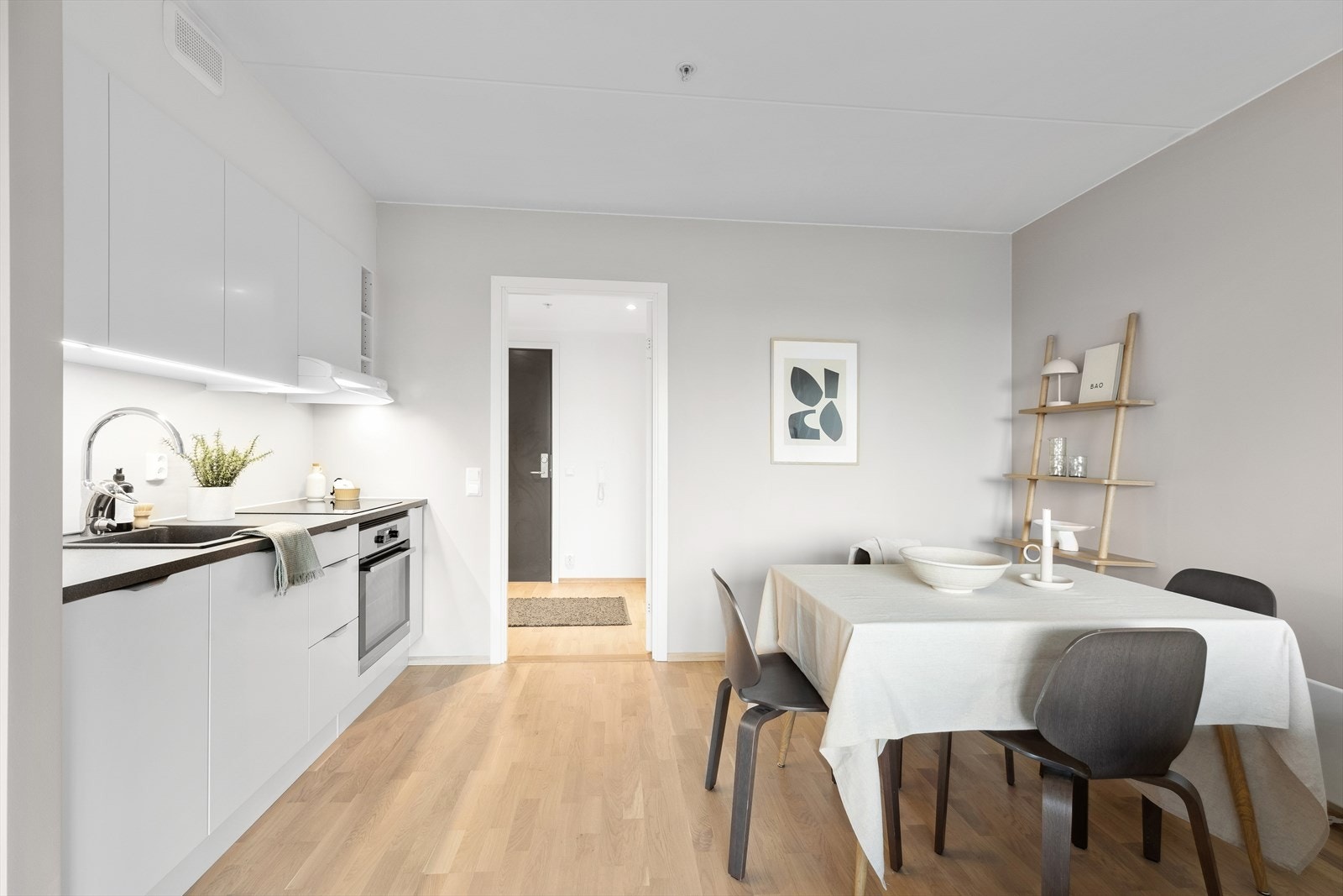 Ønsker man å utvide kjøkkenet så har flere tilsvarende leiligheter ført kjøkkenet videre på veggen bak spisebordet. Dette for å få ytterligere med benk og skapplass. Galleribilde