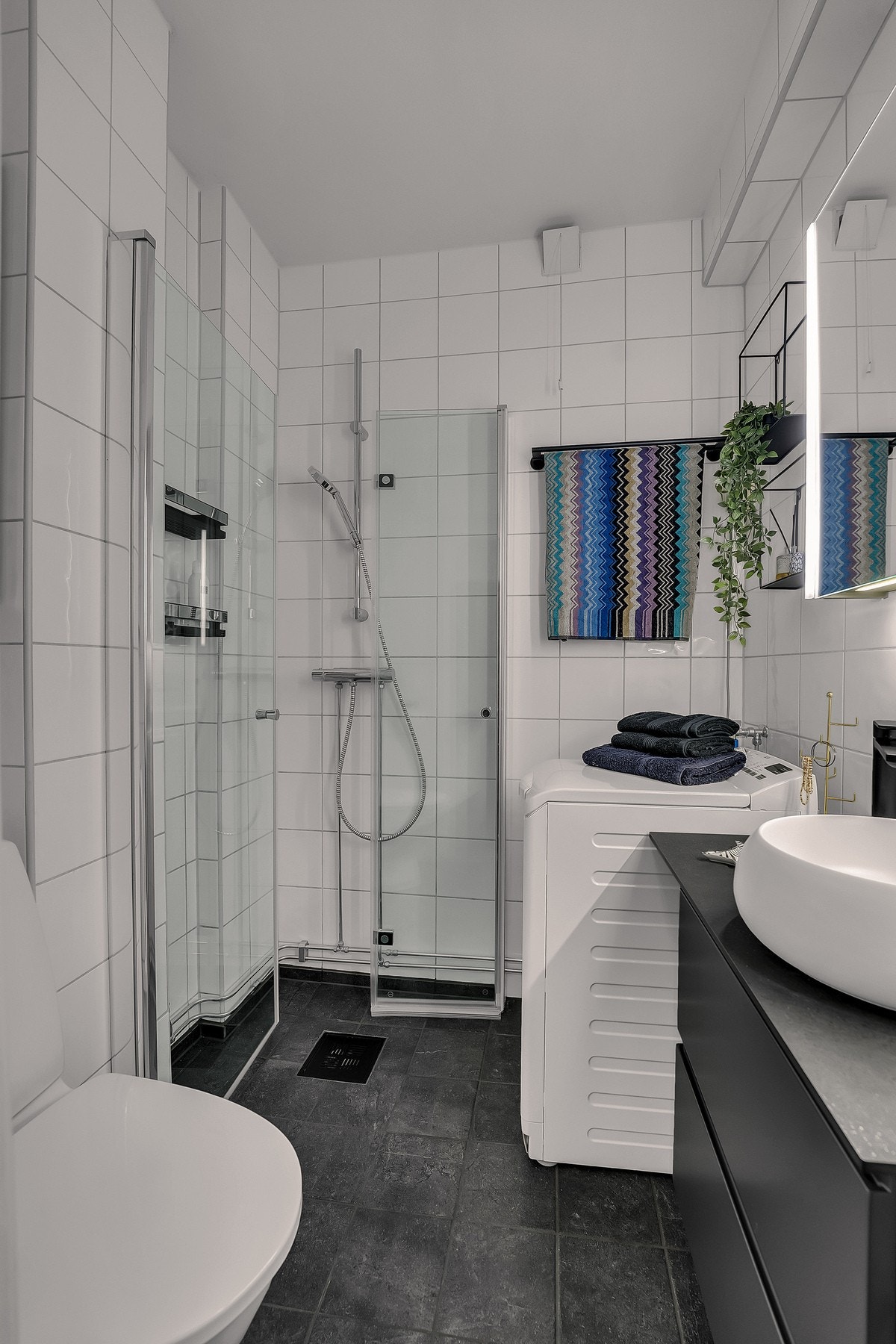 Badet inneholder servant, toalett, dusj og opplegg for vaskemaskin Galleribilde
