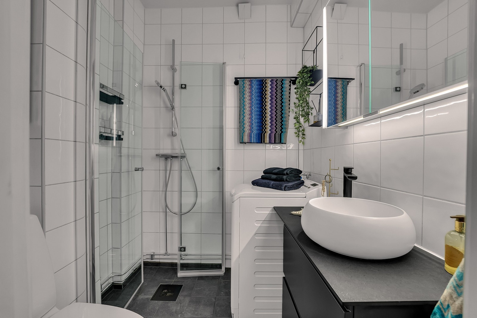 Pent flislagt bad med varmekabler i gulv og opplegg til vaskemaskin. Galleribilde