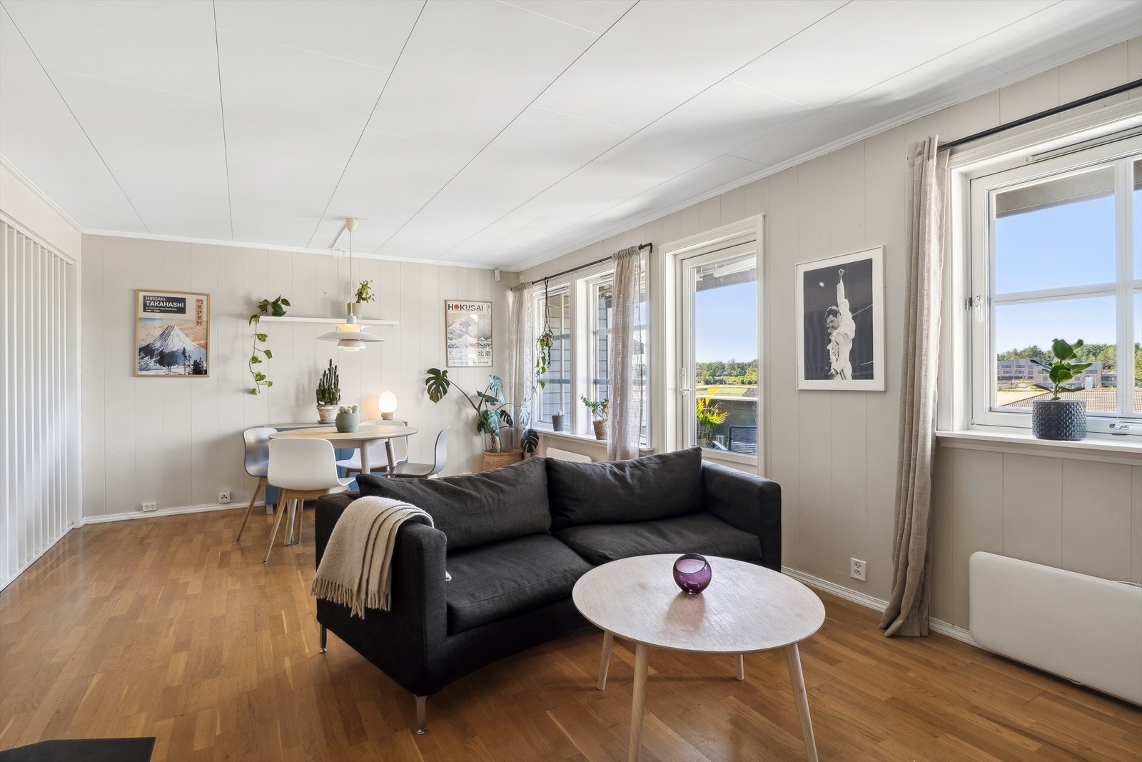 Lyst og innbydende stue med rikelig med plass både til stor sofa og spisegruppe Galleribilde