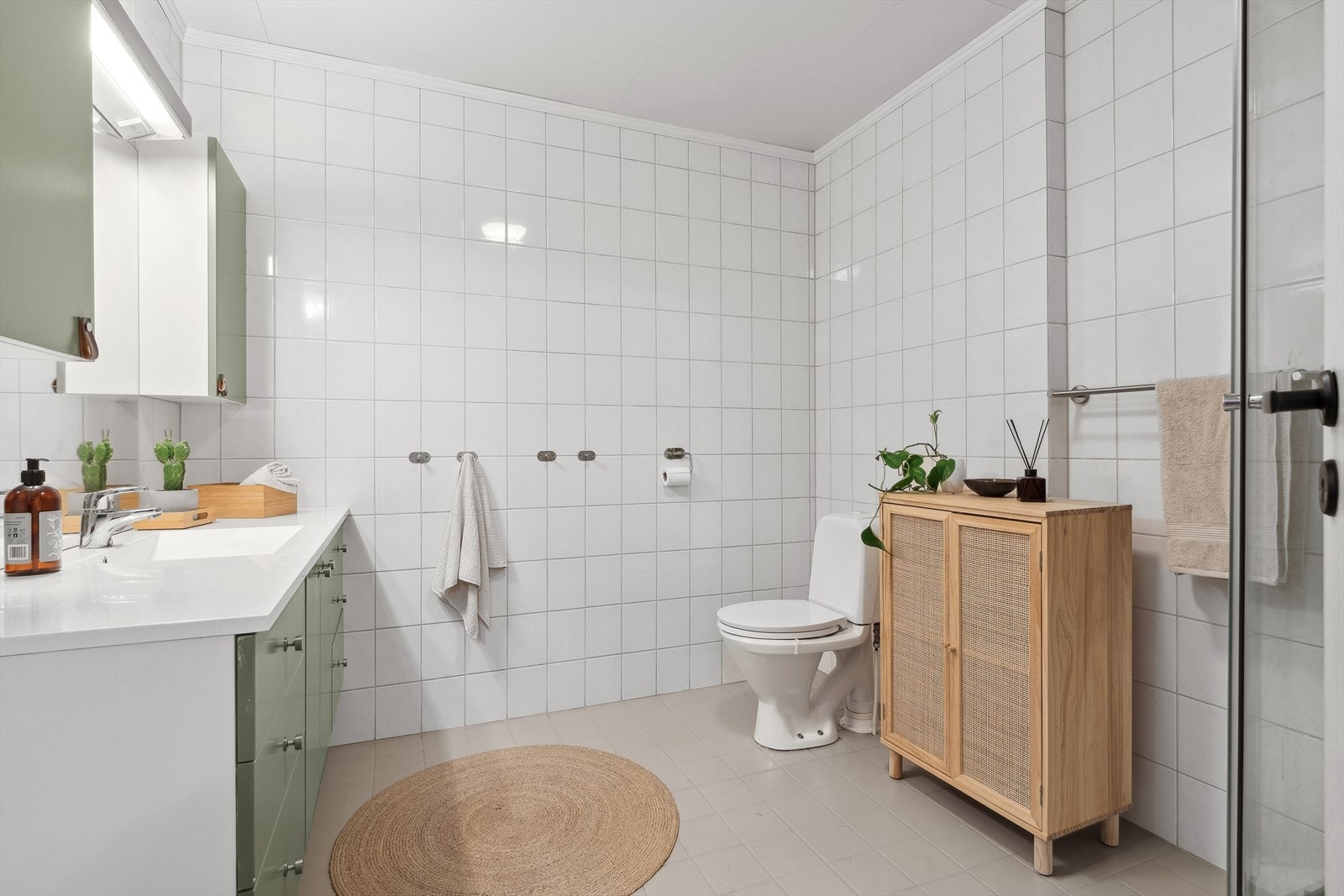 Badet er romslig og lyst, med flislagte vegger og gulv Galleribilde