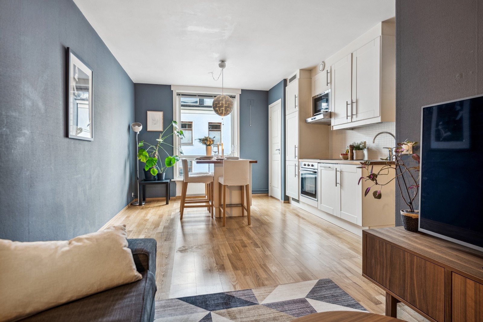 Tidløs kjøkkeninnredning med integrerte hvitevarer som komfyr, mikroovn, kjøl/frys og oppvaskmaskin. Galleribilde