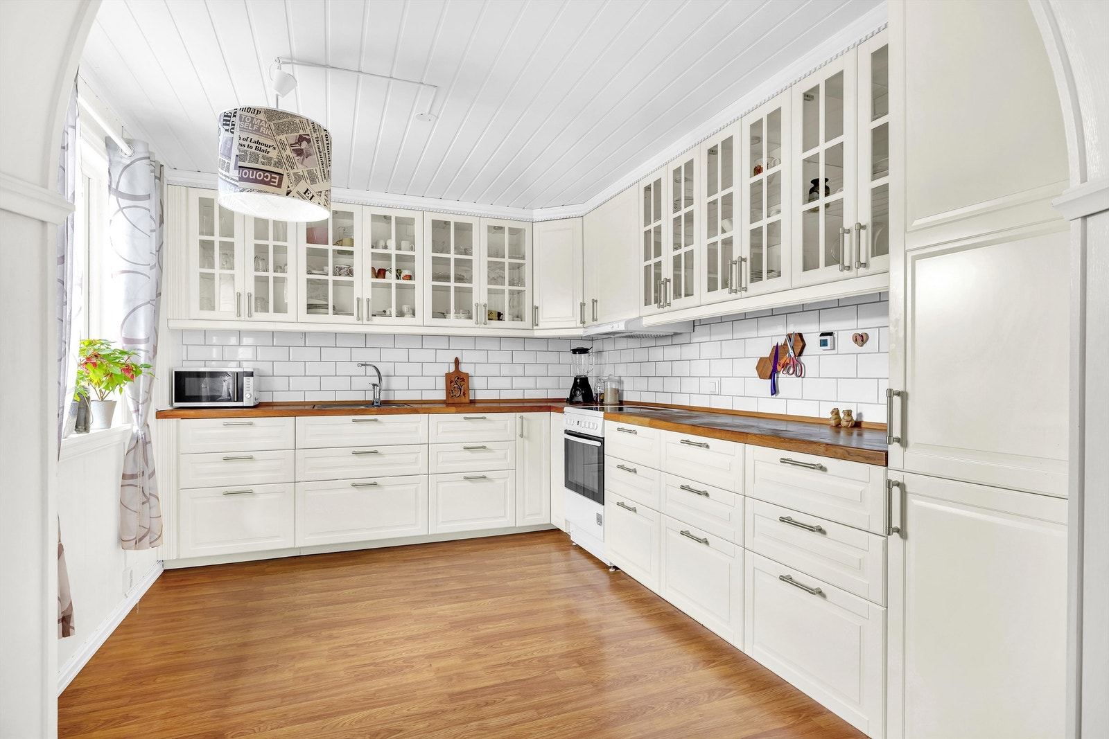 Romslig kjøkken med klassisk innredning og integrerte hvitevarer Galleribilde