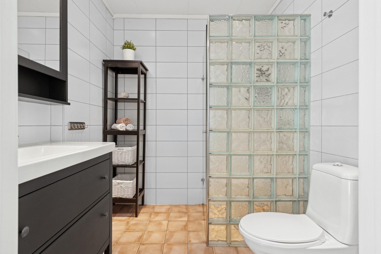 Her finner du toalett, dusjnisje m/glassfliser og baderomsinnredning - Innredningen består av servant med skuffer under og overskap med speilfronter Galleribilde