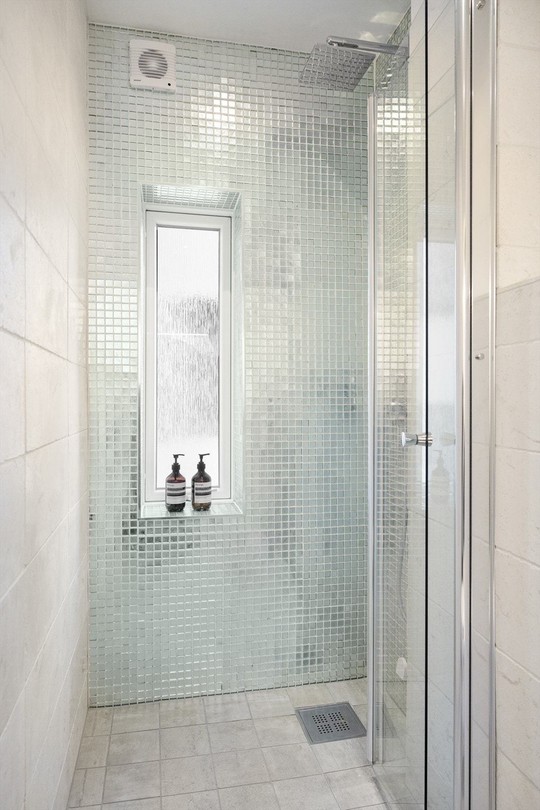 Baderommet er utstyrt med vegghengt toalett, dusjhjørne og baderomsinnredning med skuffer, benkeplate og steinvask med Tapwell ettgreps servantarmatur. Galleribilde