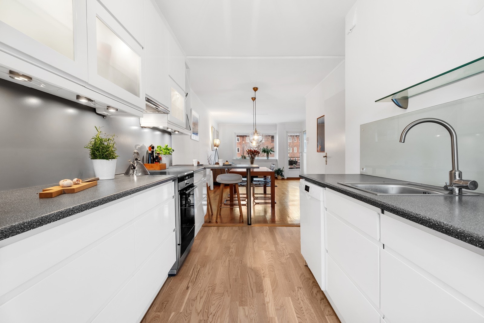 Kjøkkenet har sprutplater av glass samt stikkontakt og belysning over kjøkkenbenk Galleribilde