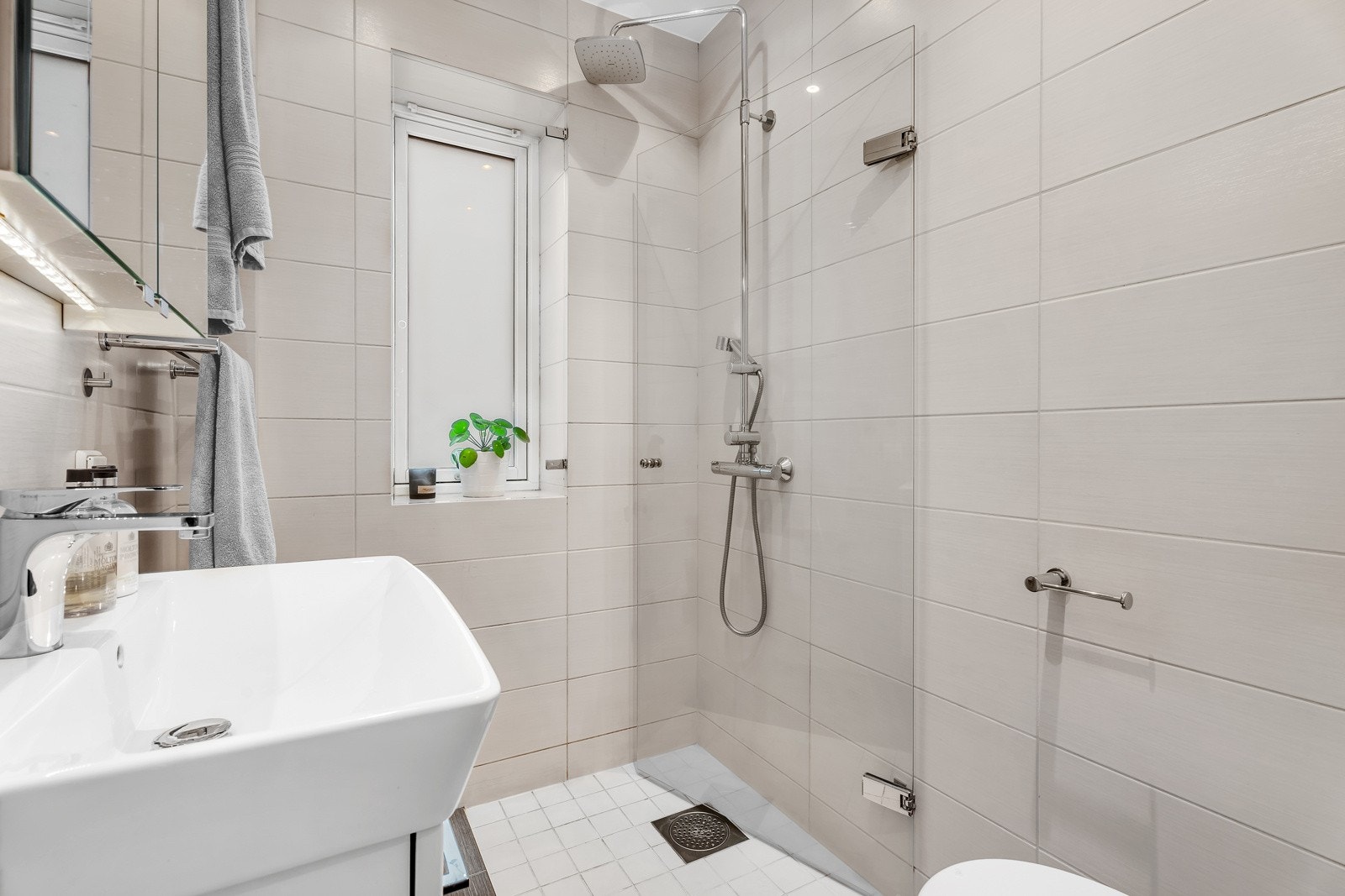 Badet har flislagt gulv med varme og flislagte vegger Galleribilde