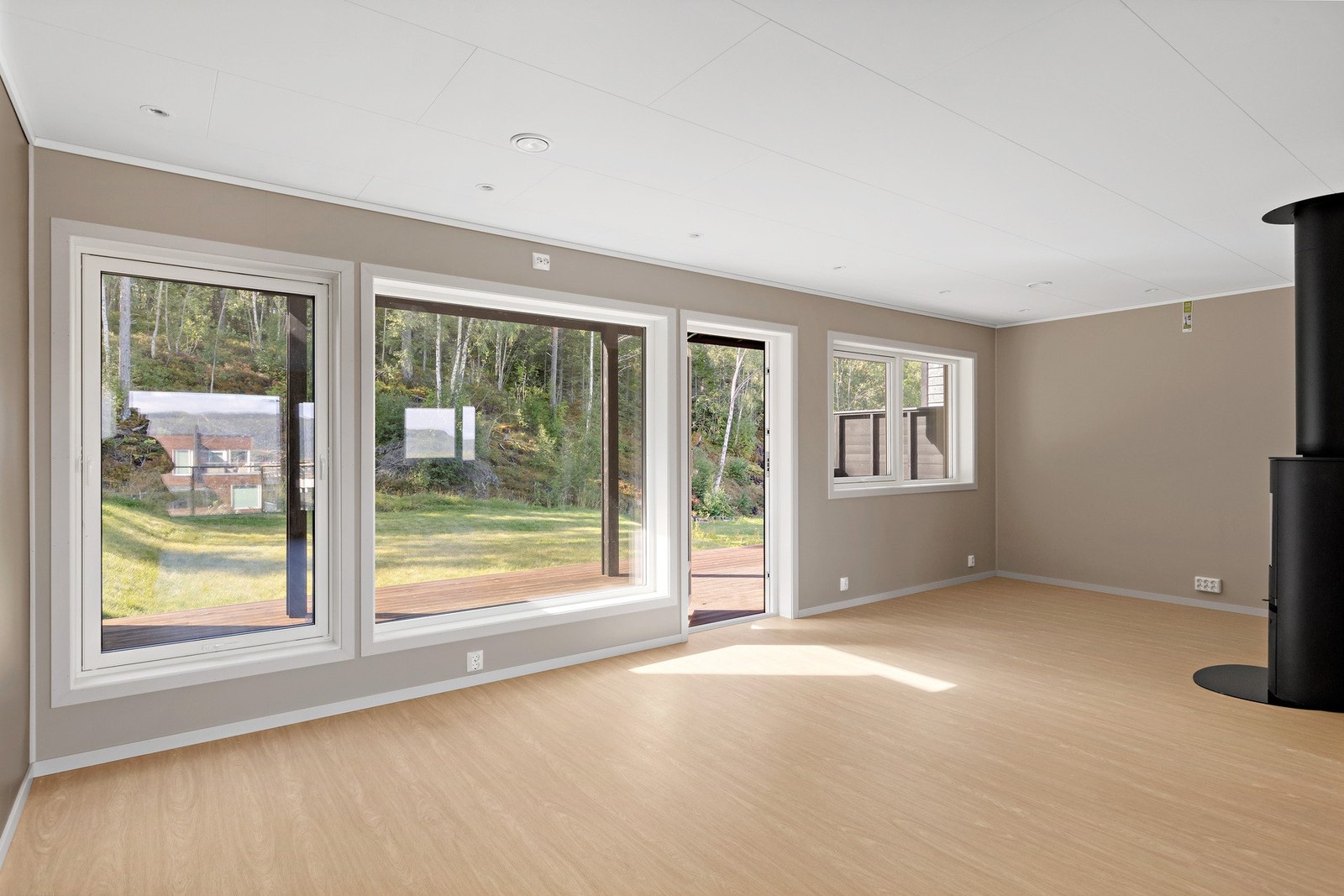 Fra stue i 1.etasje er det utgang til terrasse og hage. Eiendommen grenser til skog som er friareal. Galleribilde