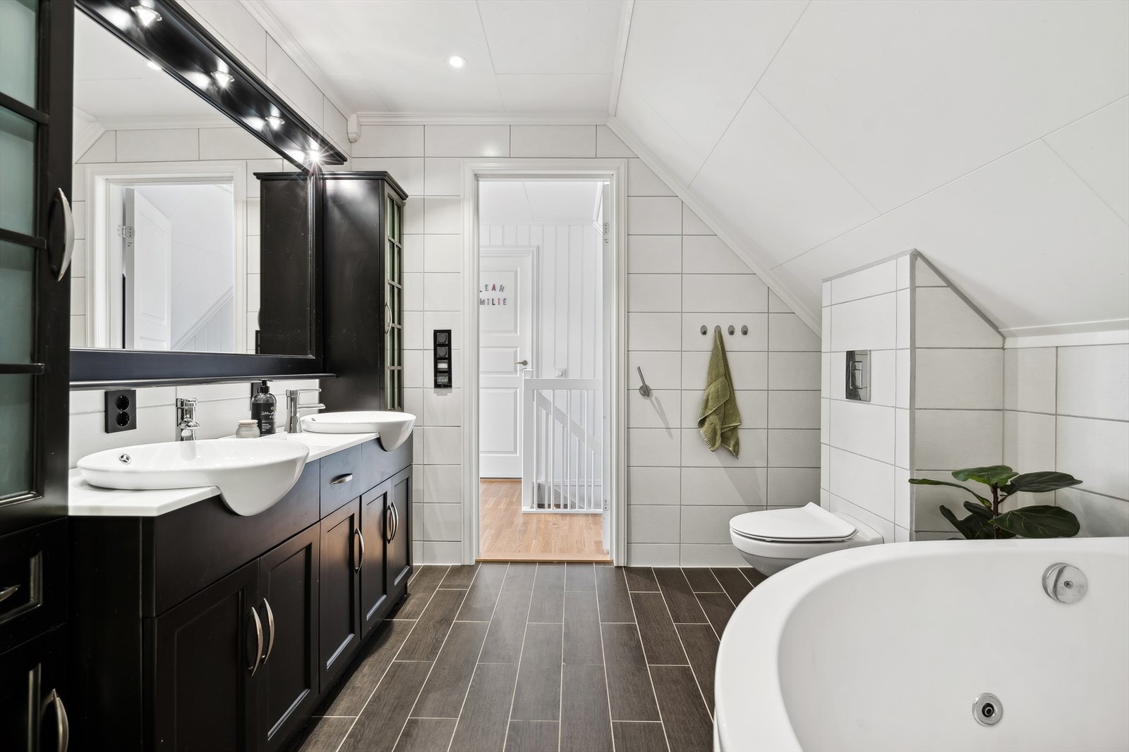 Badet er utført med mørke gulvfliser m/elektriske varmekabler og hvite veggfliser Galleribilde