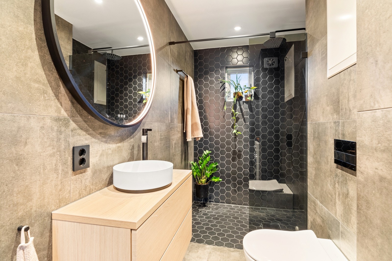 Moderne flislagt bad fra 2022 av god størrelse, med dusjhjørne og vegghengt wc Galleribilde