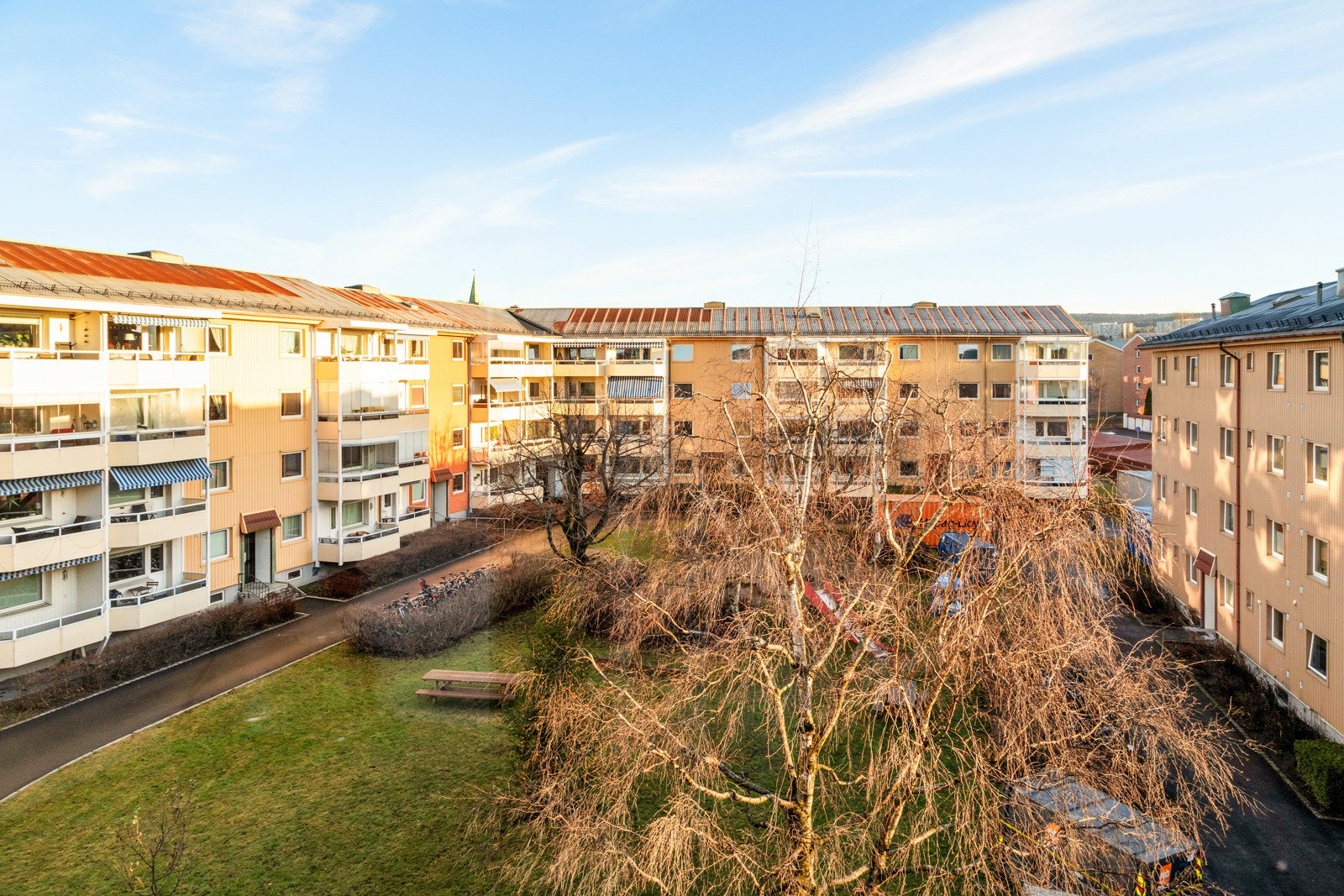 Fra kjøkkenet er det hyggelig utsyn over felles uteområder med grønne plener og lekeaparater Galleribilde