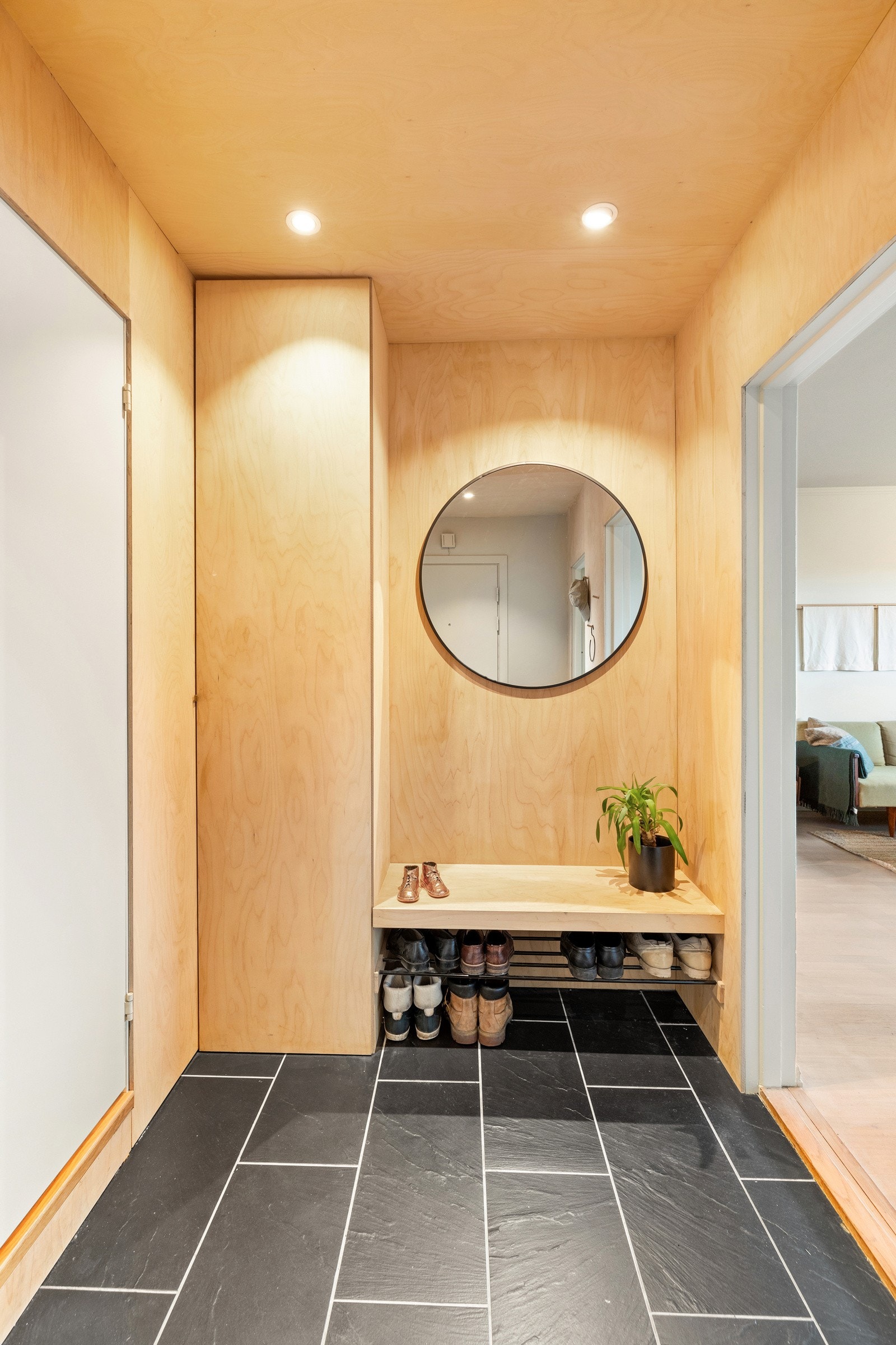 Innbydende entré med sittebenk og skohylle, og praktisk oppbevaring i garderobeskap Galleribilde