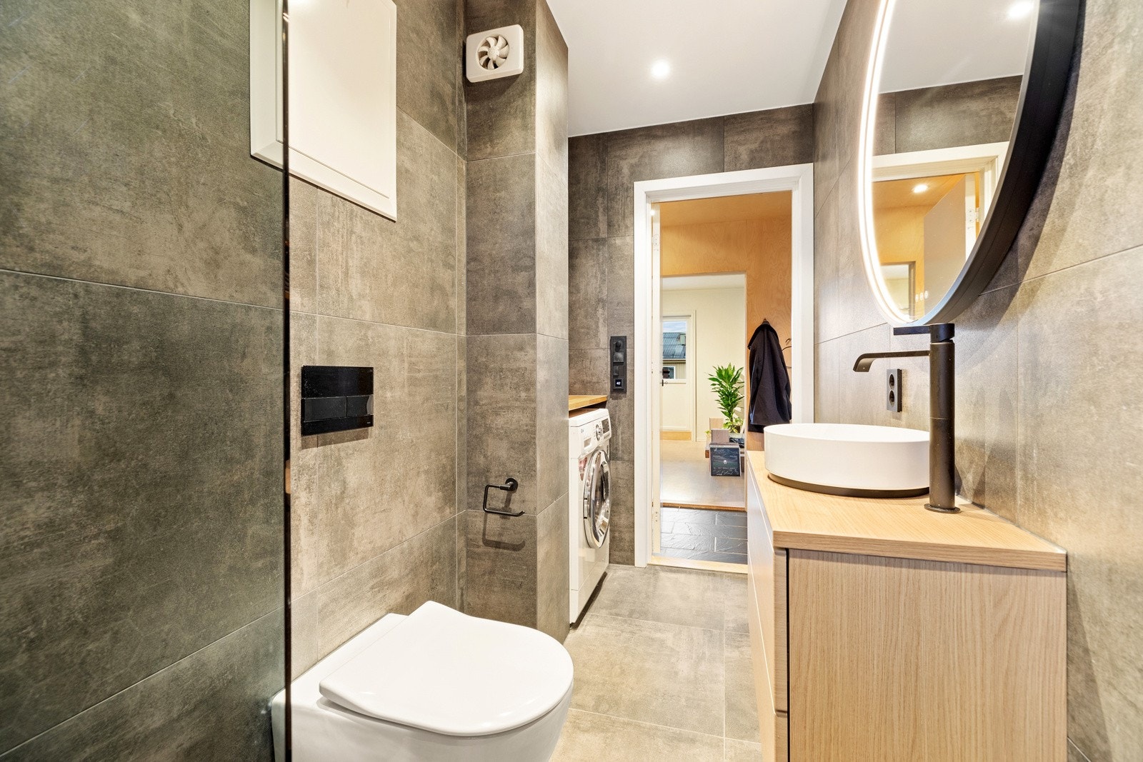 Badet har stort speil og vegghengt servantinnredning med god oppbevaringsplass Galleribilde