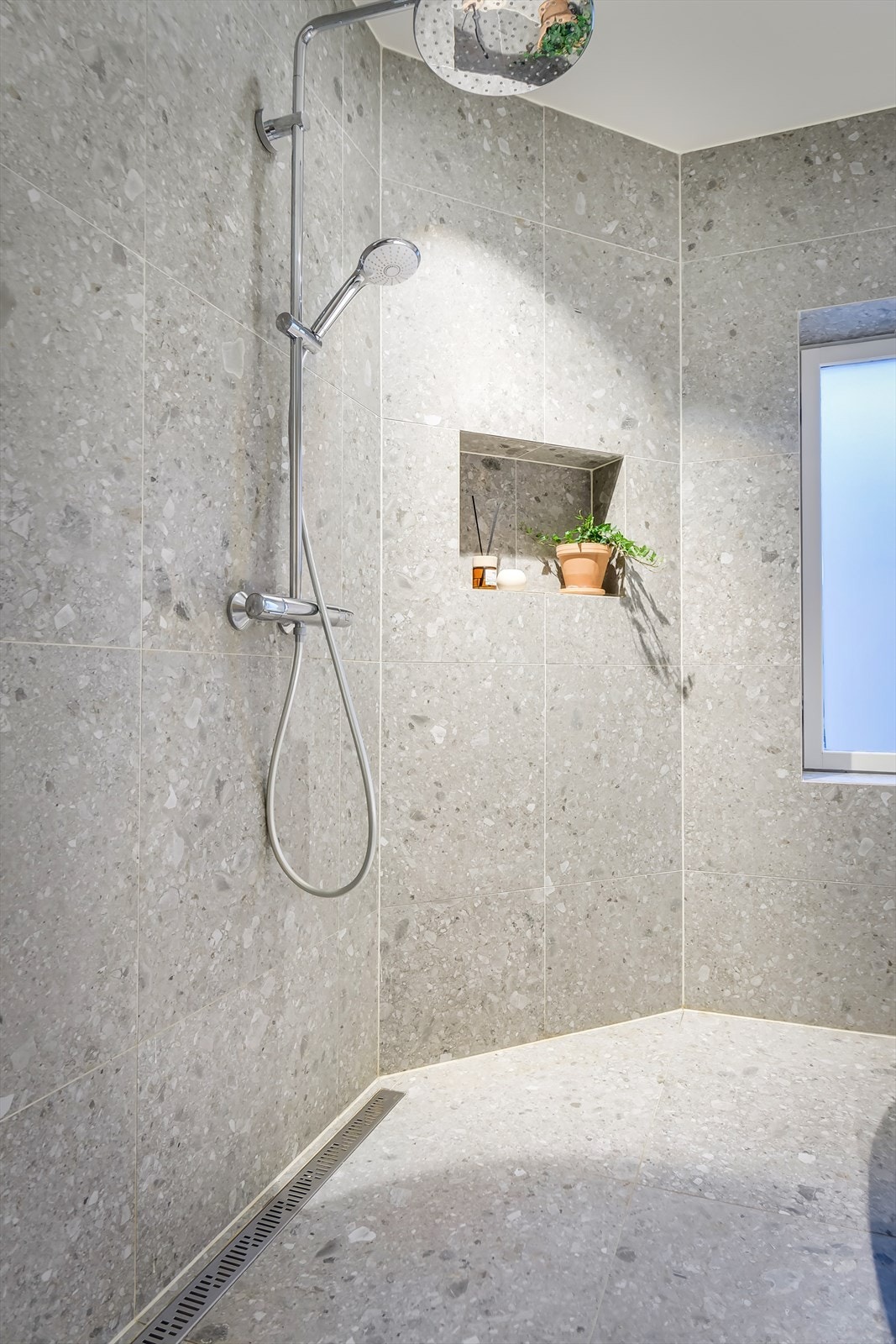 Badet ble totalrenovert i 2021, og er utstyrt med vegghengt toalett med innebygd sisterne, servantinnredning med skuffer og speil med dimmbart sminkelys Galleribilde